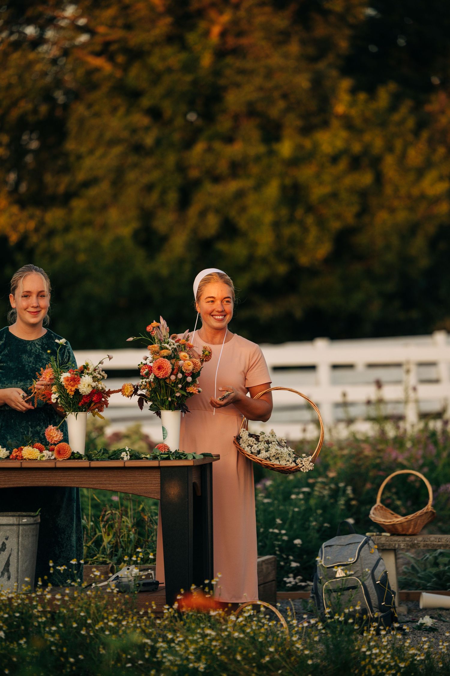 Flower arranging workshop in outdoor garden setting during golden hour.