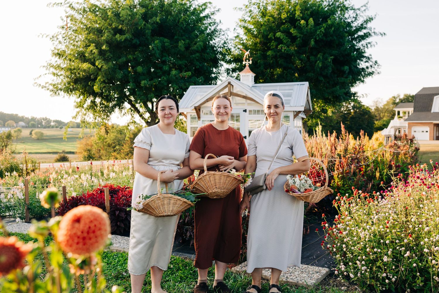 Gardeners display their freshly harvested flowers in baskets at a flower farm.