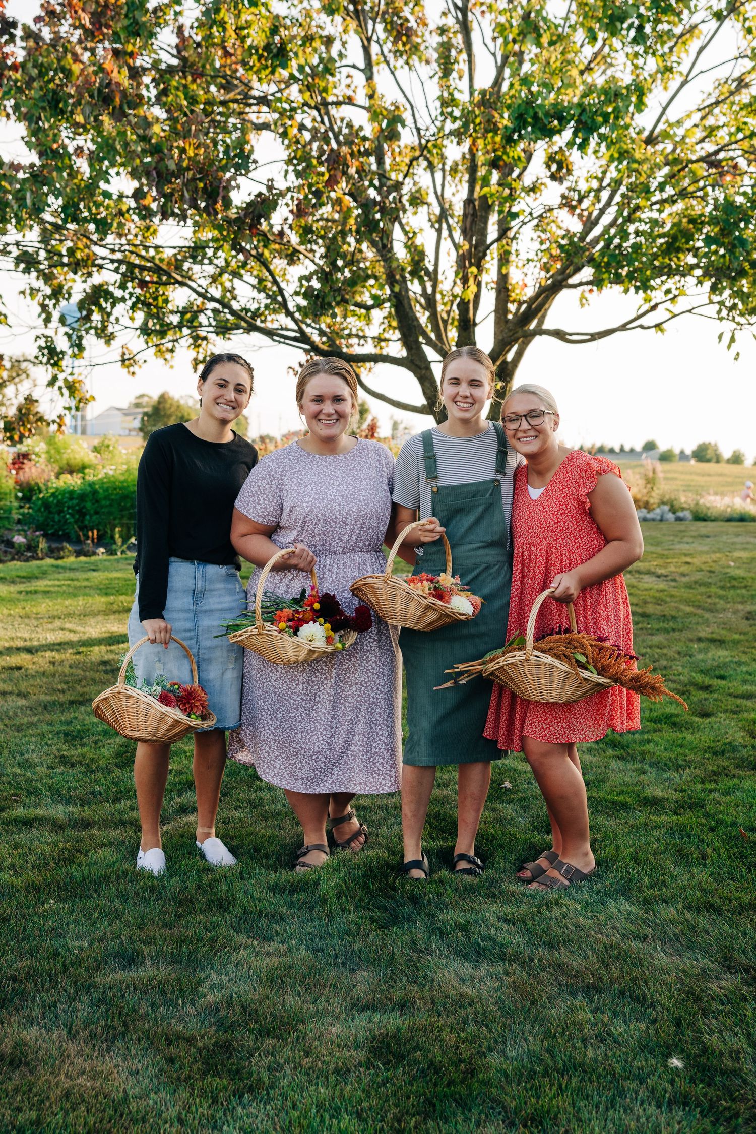 Group photo of flower farm workers holding baskets of freshly harvested blooms.