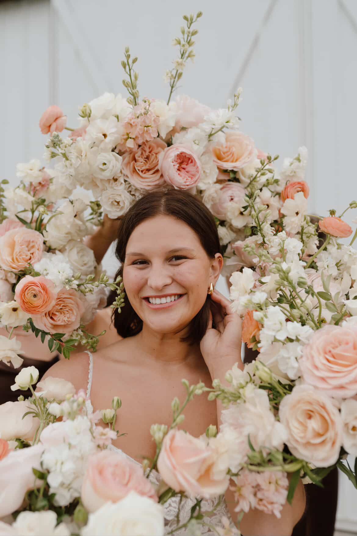 Beautiful floral arrangement with peach roses and white blossoms creating a romantic wreath design.
