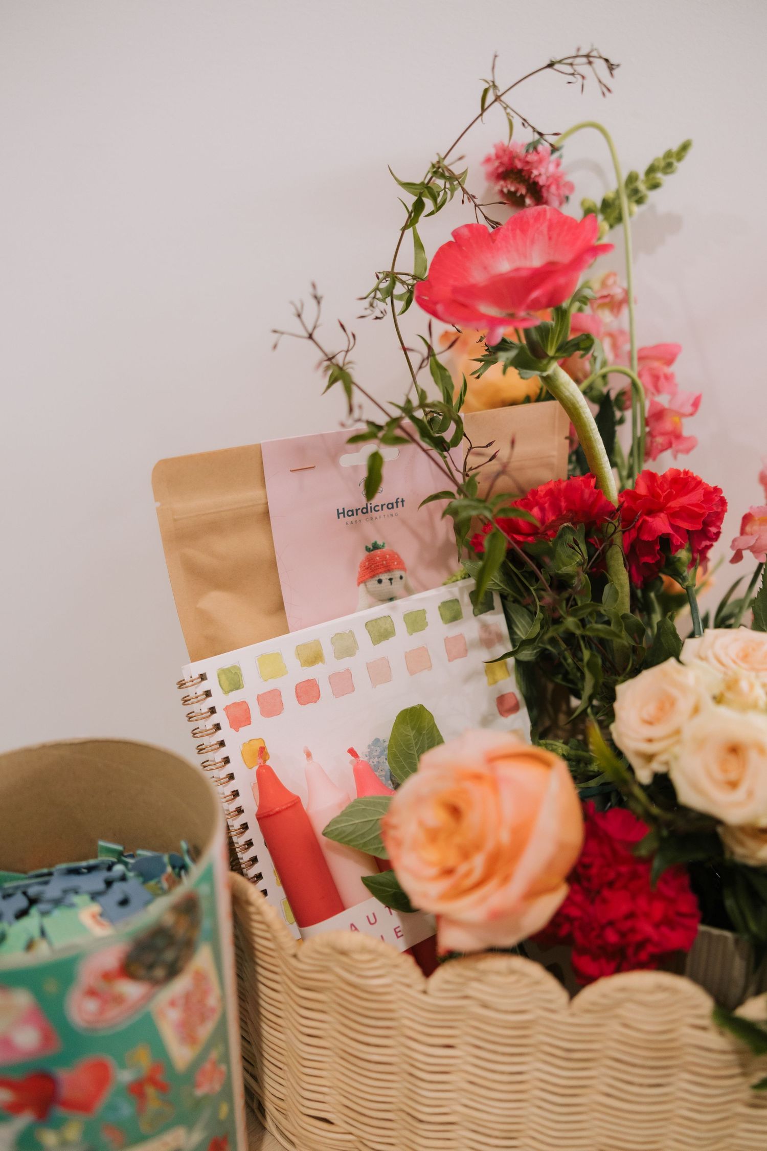 A collection of fresh pink and coral roses arranged with notebooks and paper products in a decorative display.
