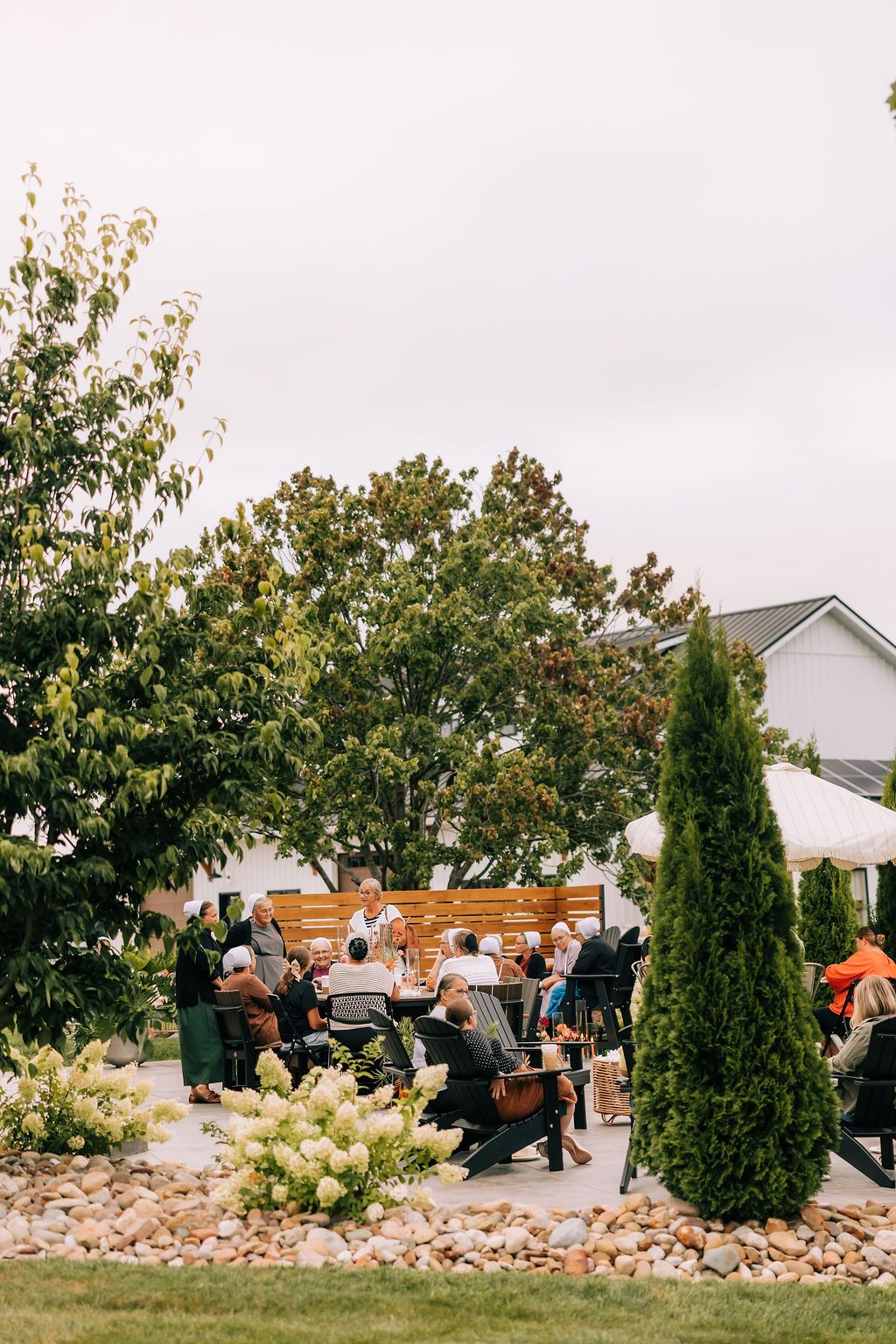 A group of people working together to build a rock wall or landscaping feature in a residential yard.