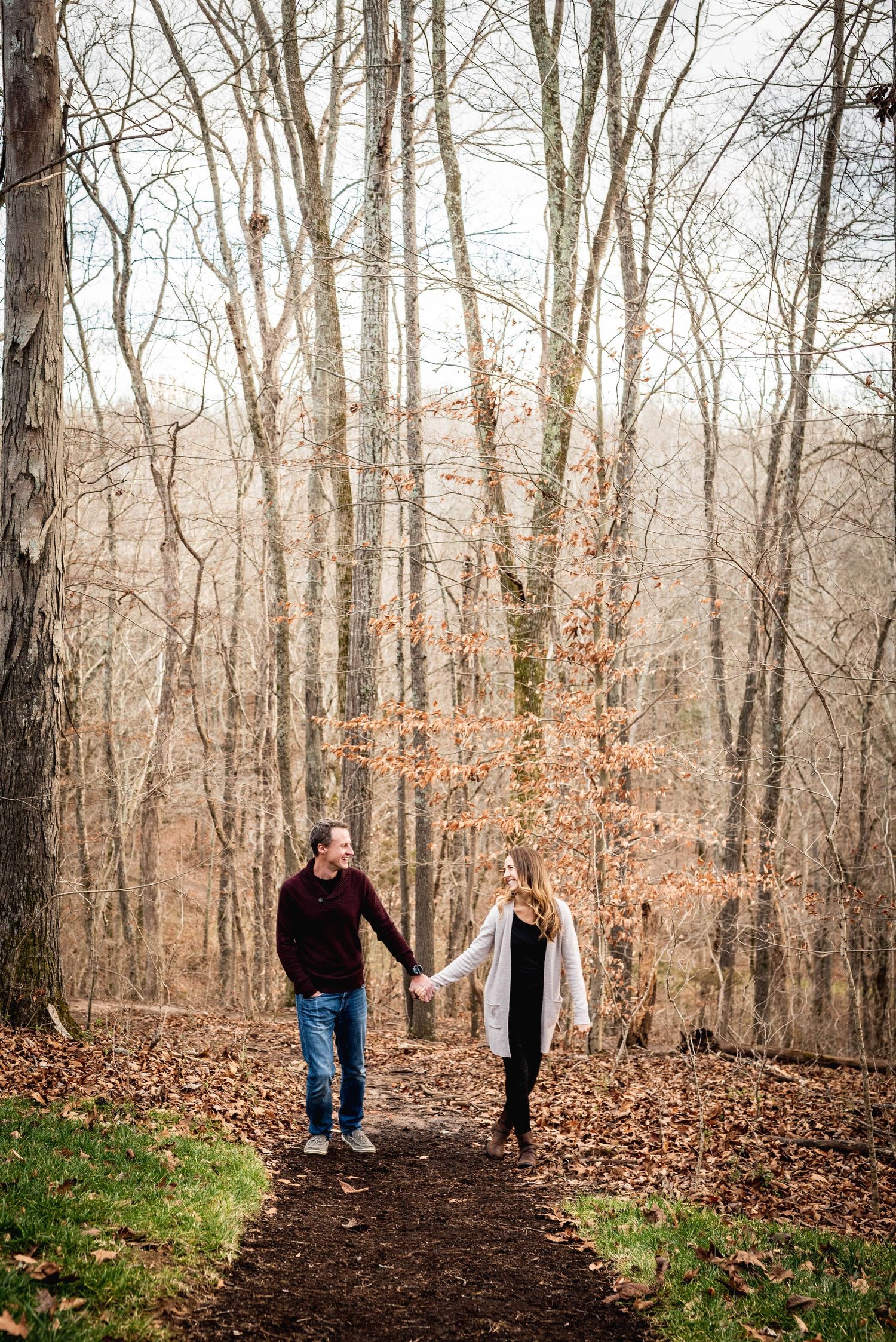 Romantic photo of attractive couple holding hands in the woods during a family photo session or engagement photo shoot in Clarksville, TN