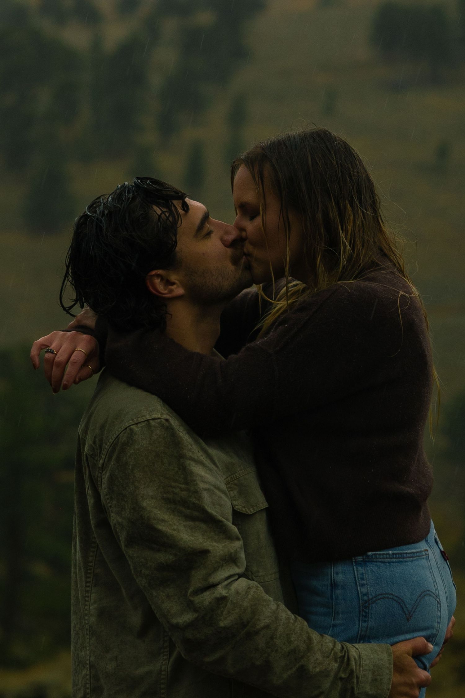 A couple kissing passionately in the rain in the romantic setting of Rocky Mountain National Park, Colorado.