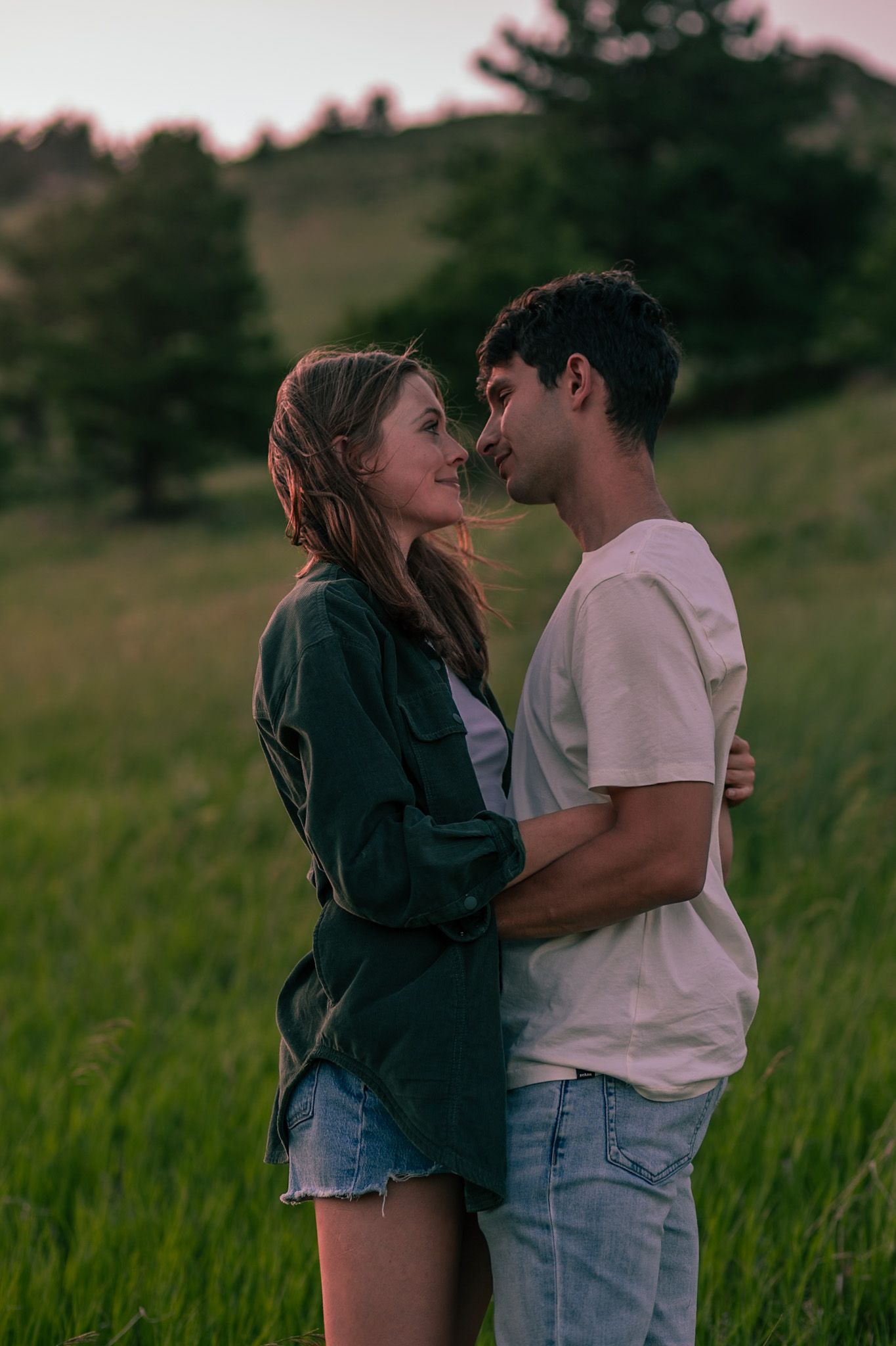 Couple embracing with the mountainous backdrop of Horsetooth Falls in Fort Collins, Colorado.