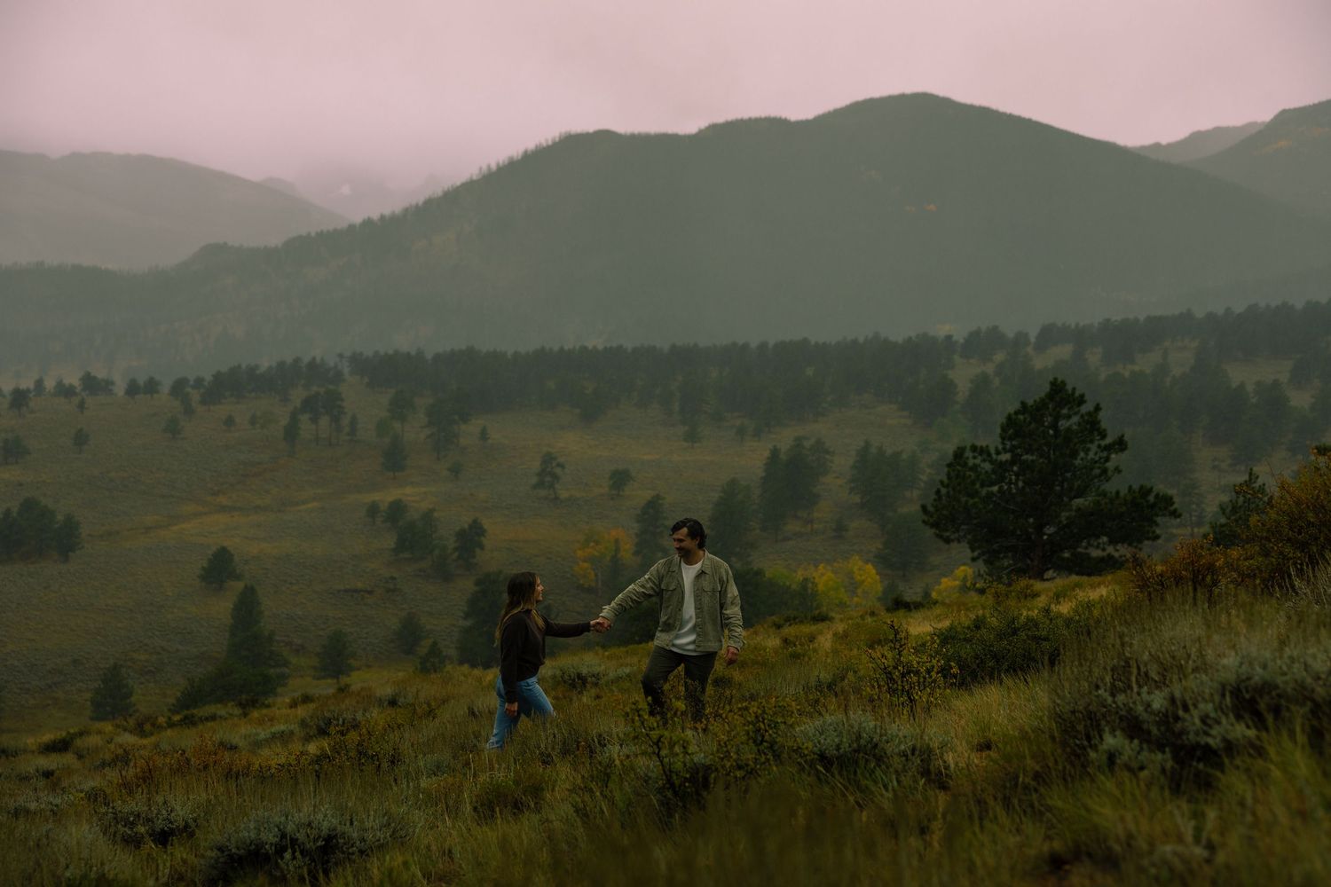 A couple exploring in the rain in the romantic setting of Rocky Mountain National Park, Colorado.
