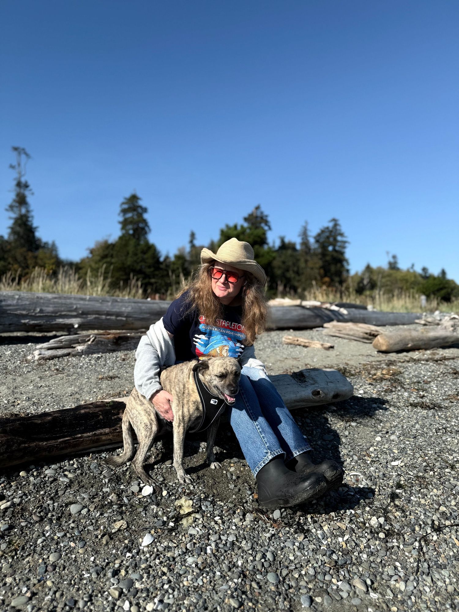 Family portrait session at Fay Bainbridge on Bainbridge Island. WA. Woman with family dog on beach.