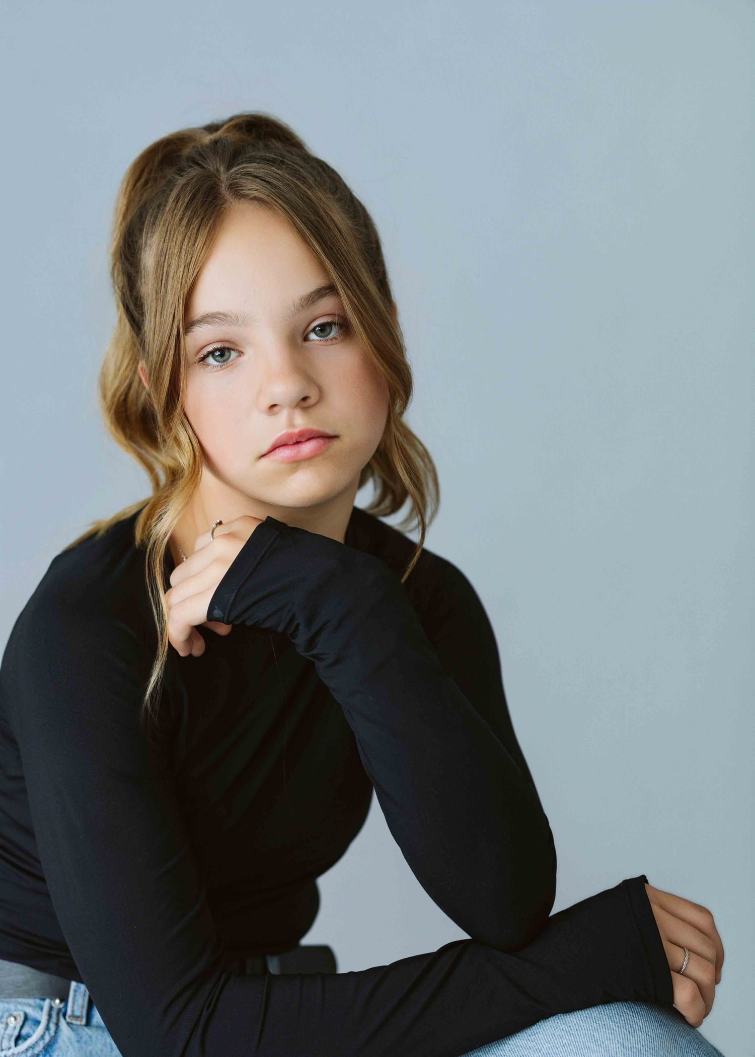 Portrait series in black turtleneck showing various casual poses against light background.