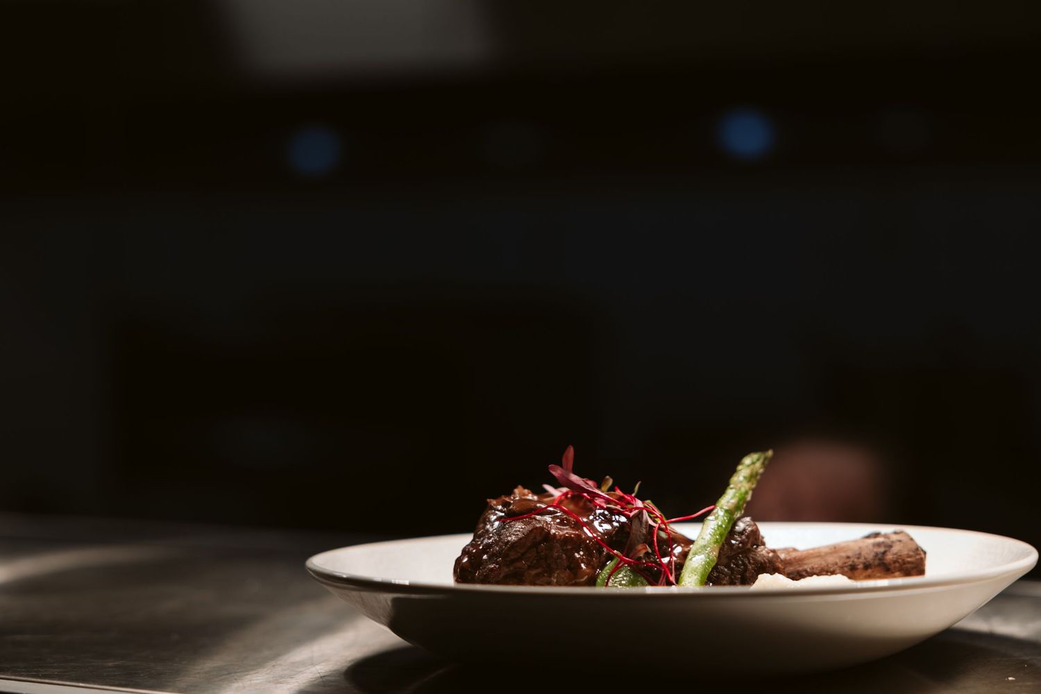 Dark atmospheric restaurant setting with blurred bokeh lights in the background.