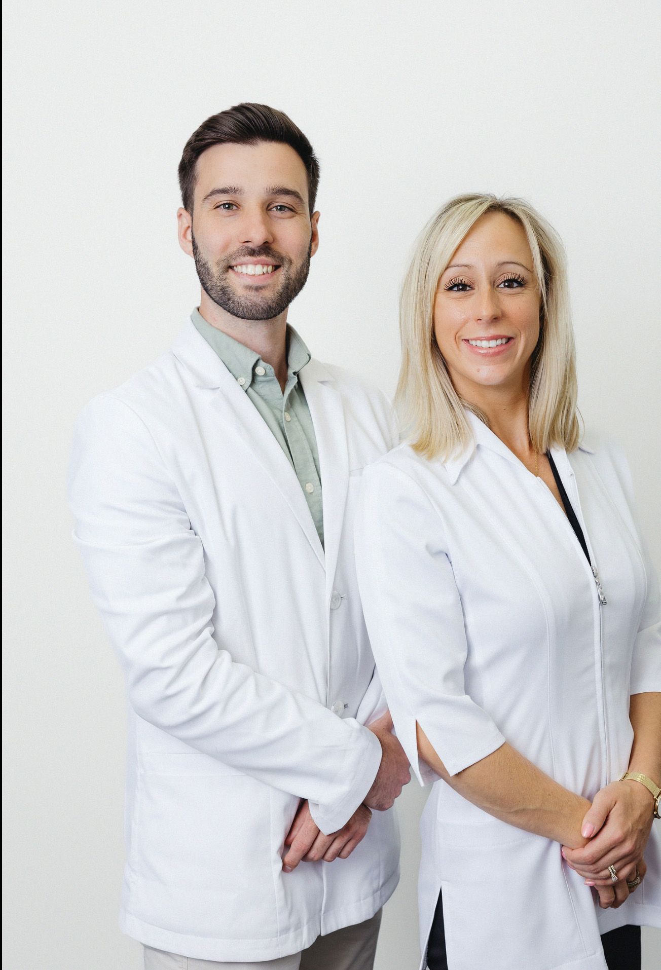 Healthcare professionals in white coats standing together against white background.