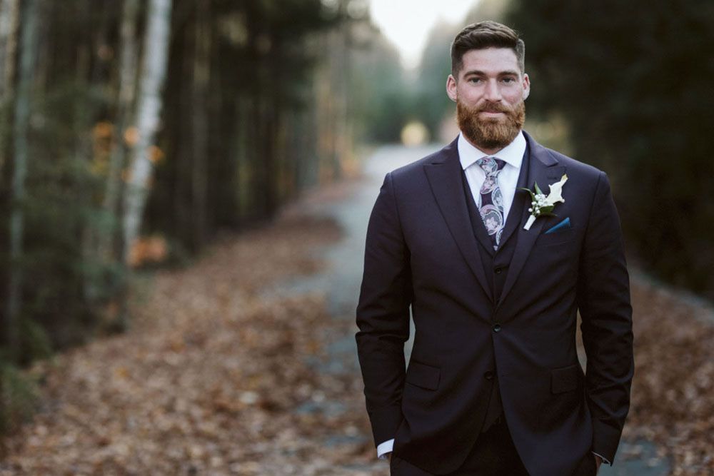 Groom portraits in formal attire against natural autumn forest backdrop.