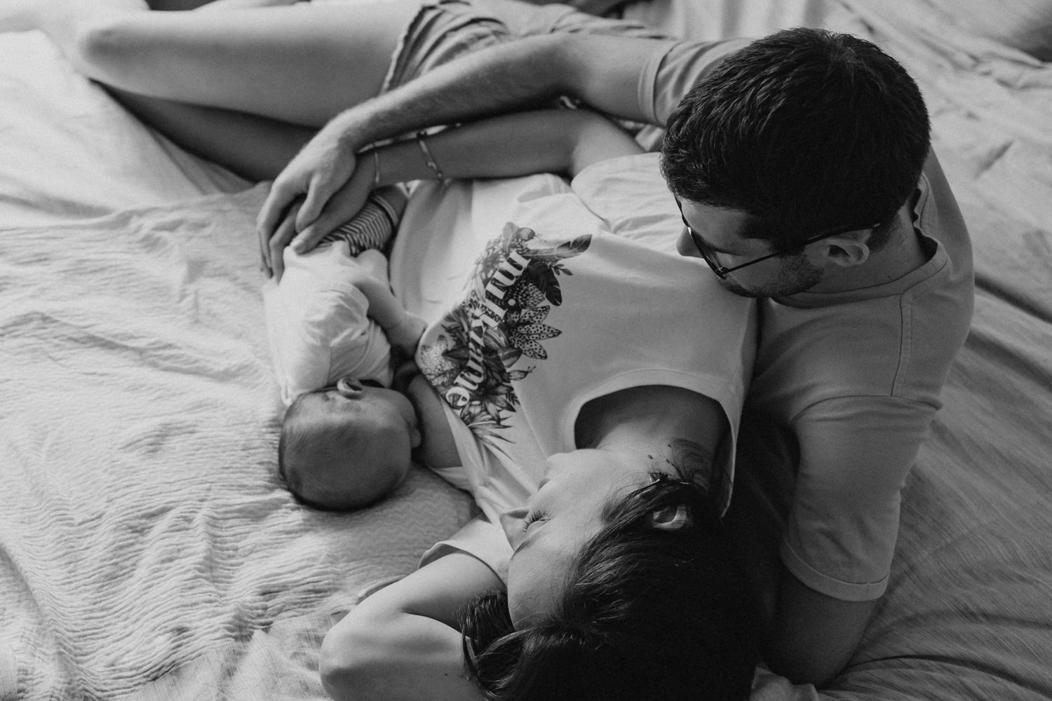 Intimate black and white maternity photos on white bedding.