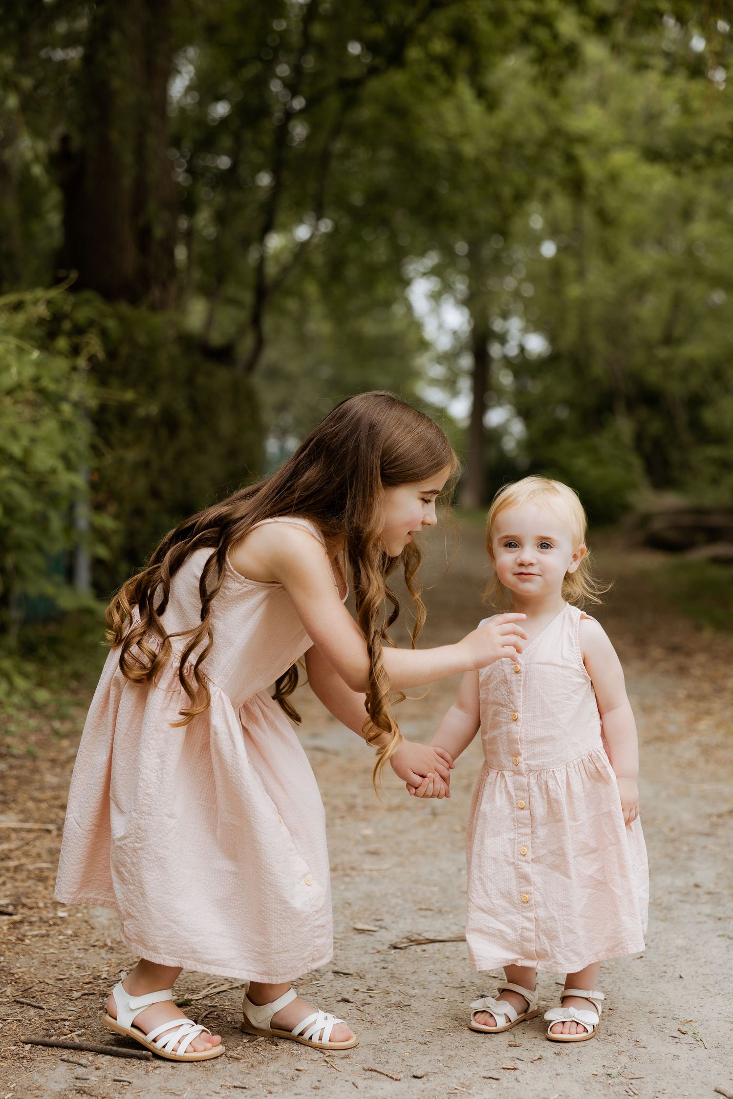 Series of photos showing a tender moment between parent and child in matching pink dresses outdoors.