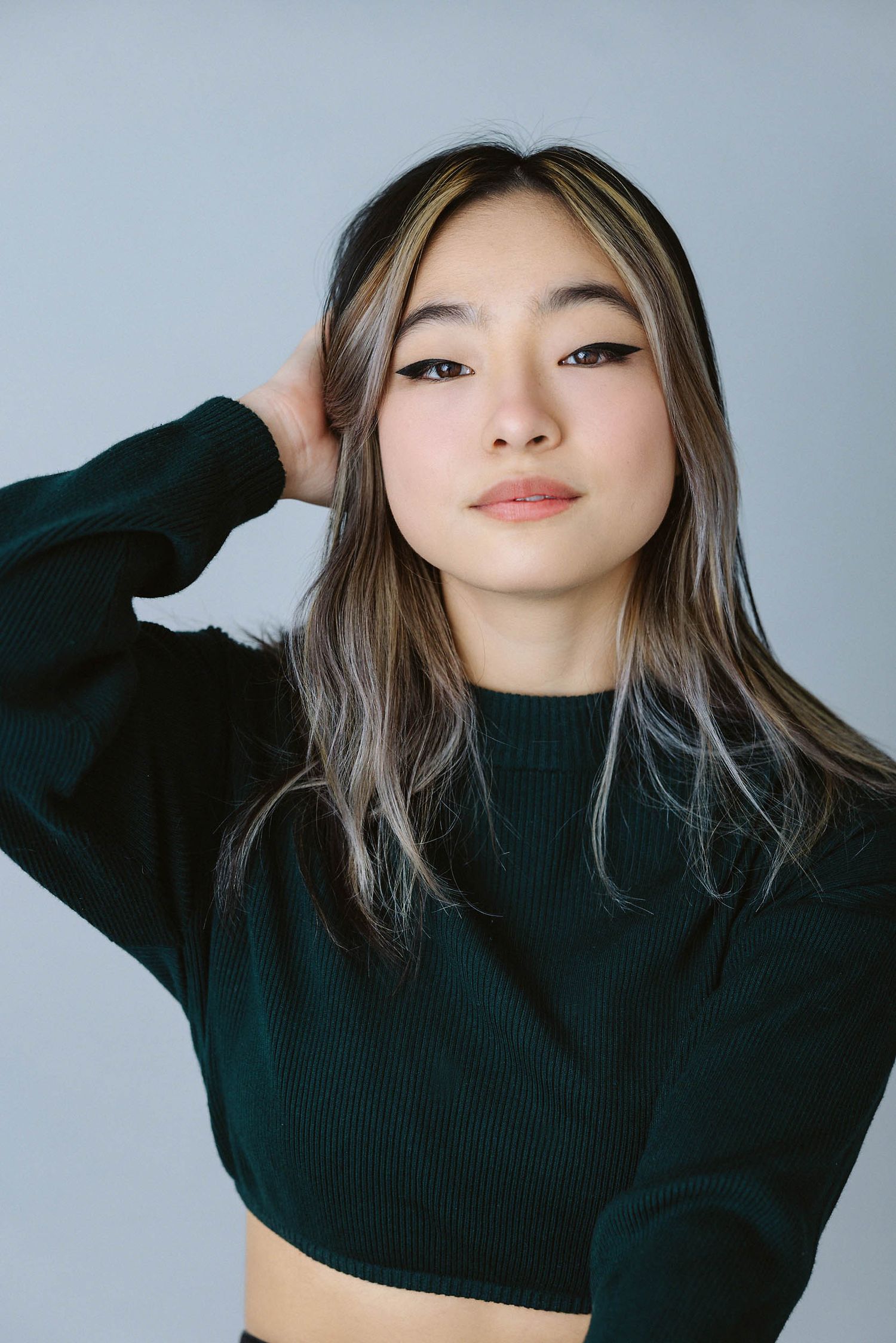 Fashion portraits showing model in black sweater against light gray background.