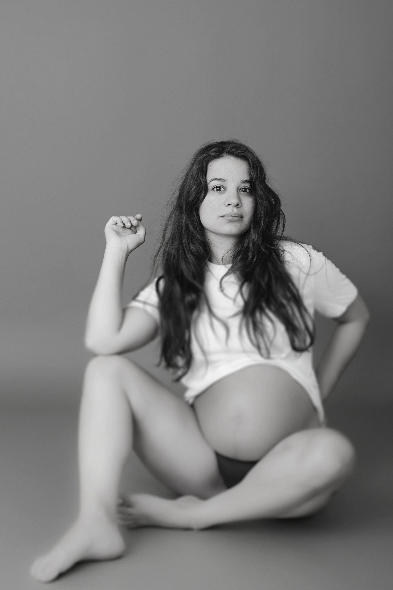 Black and white maternity portrait in casual white t-shirt.