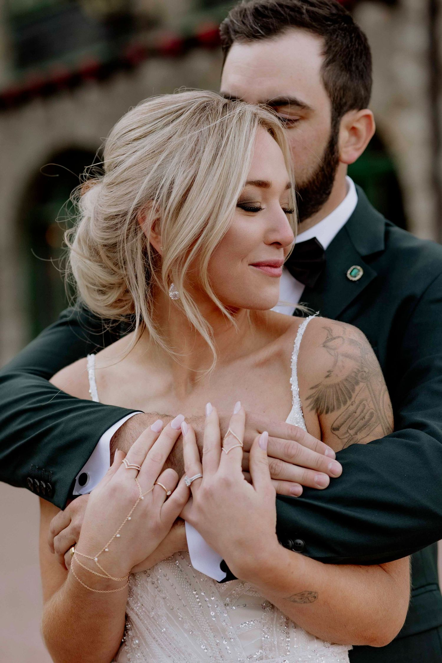 Close-up shots of tender moments between newlyweds against stone building.