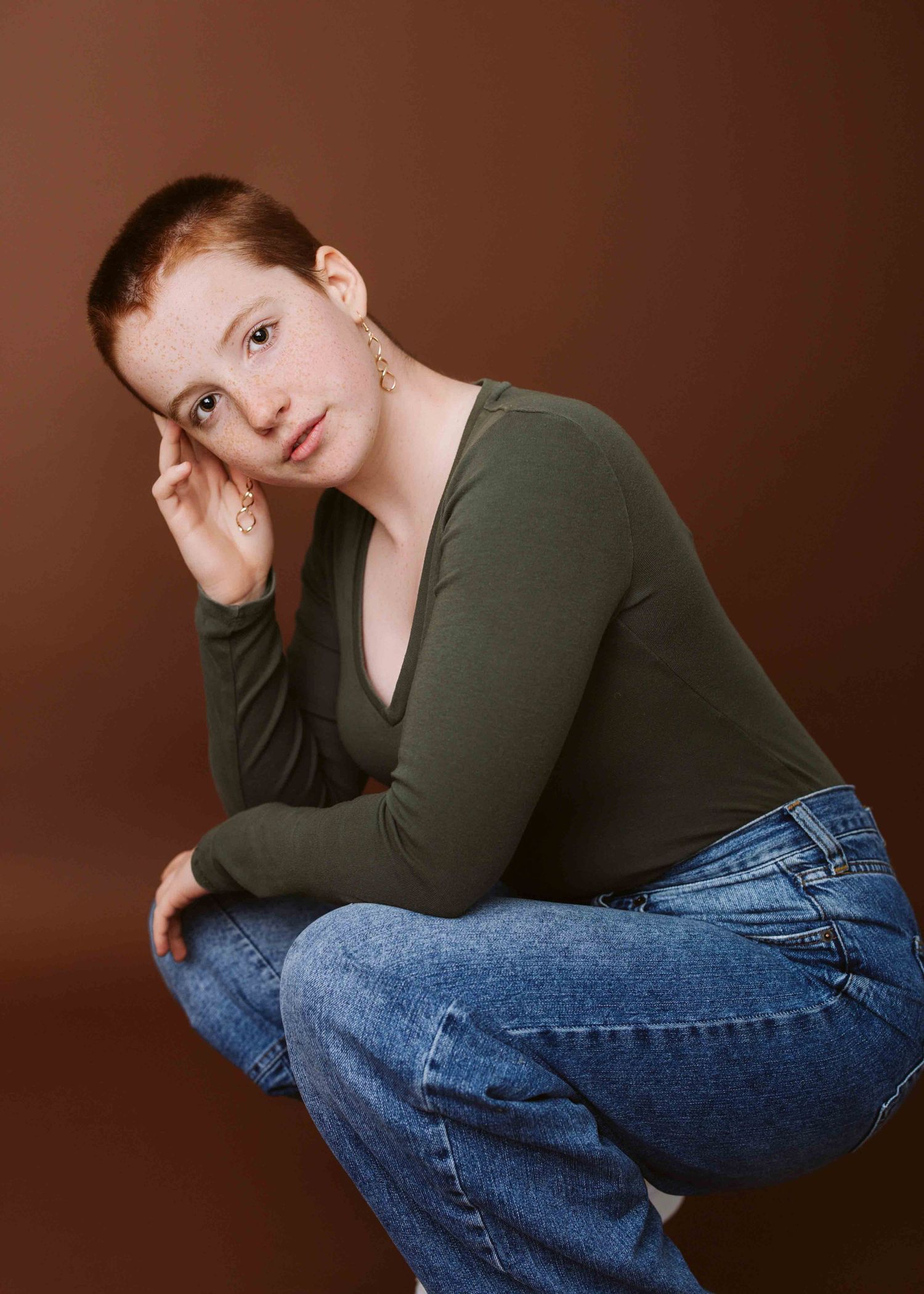 Casual portrait in olive sweater and jeans with natural styling.