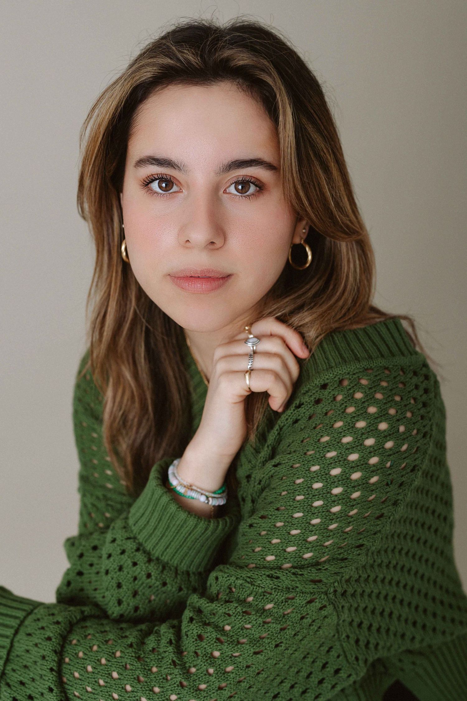 Portrait series in green knit sweater showing casual poses against neutral background.