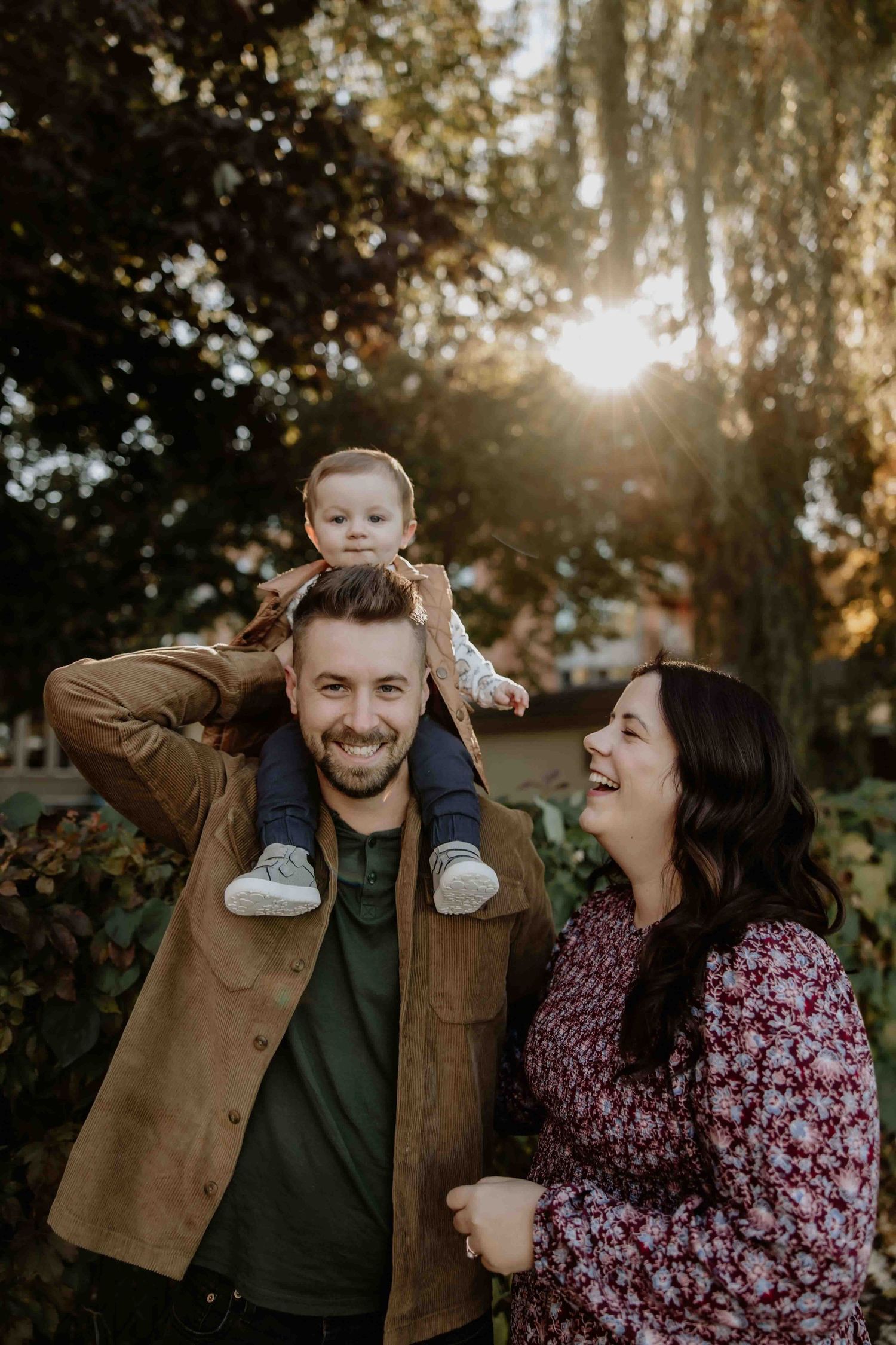 A family enjoying a candid moment together in autumn sunlight.