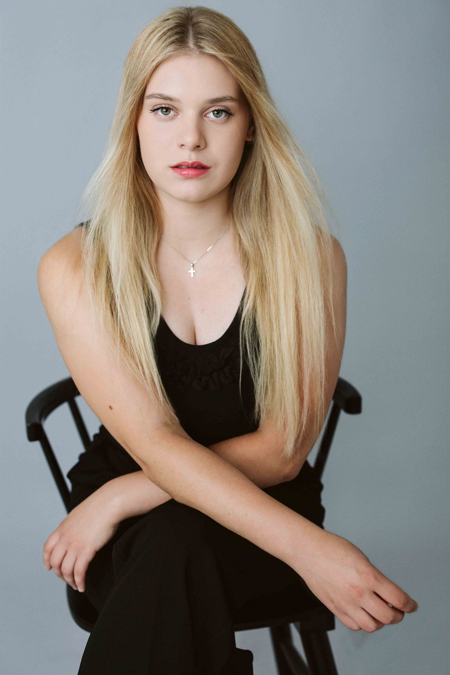 Fashion portrait series featuring blonde model in black outfit against gray backdrop.
