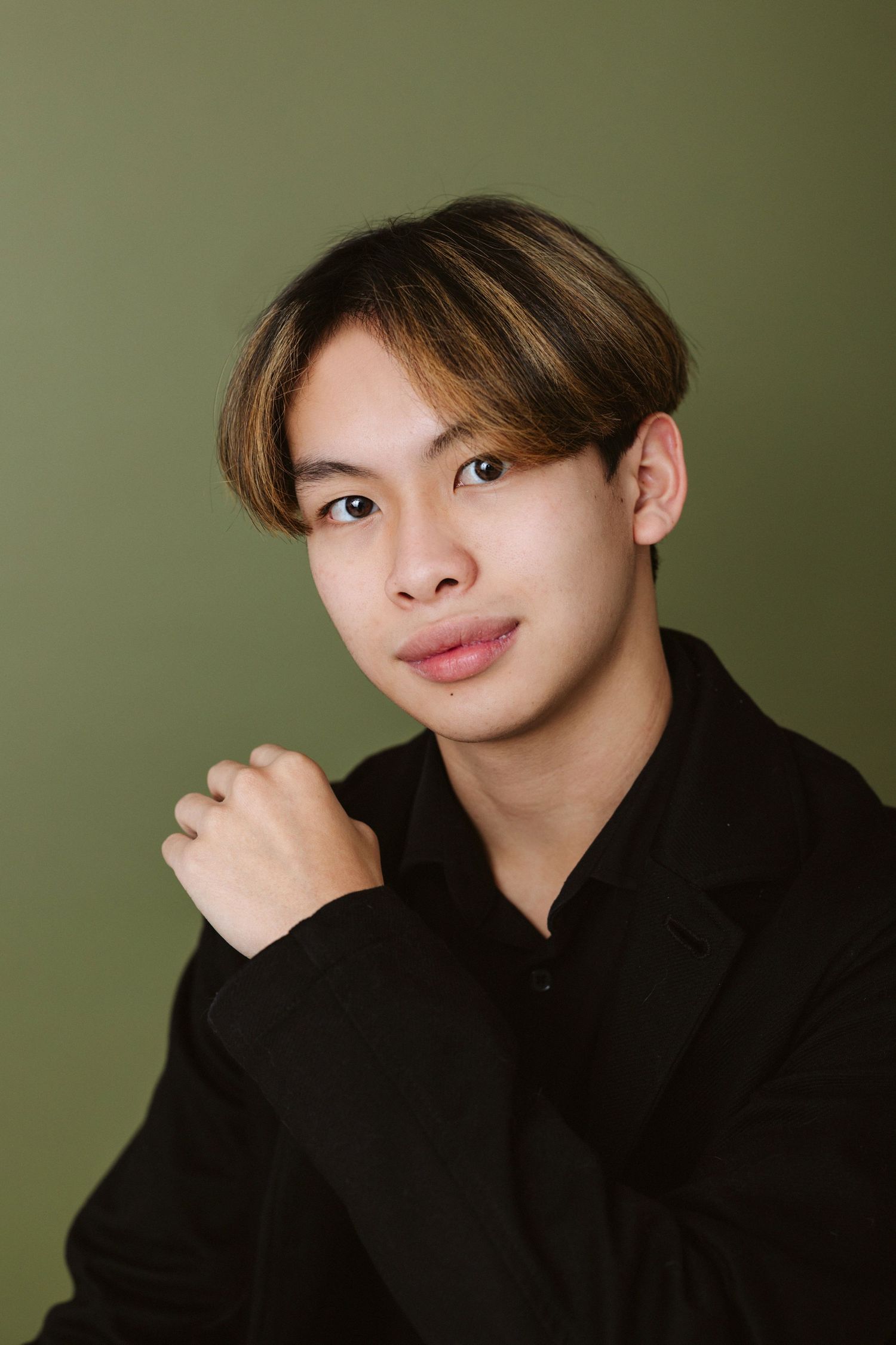 Portrait series showing confident poses in black turtleneck against olive green background.
