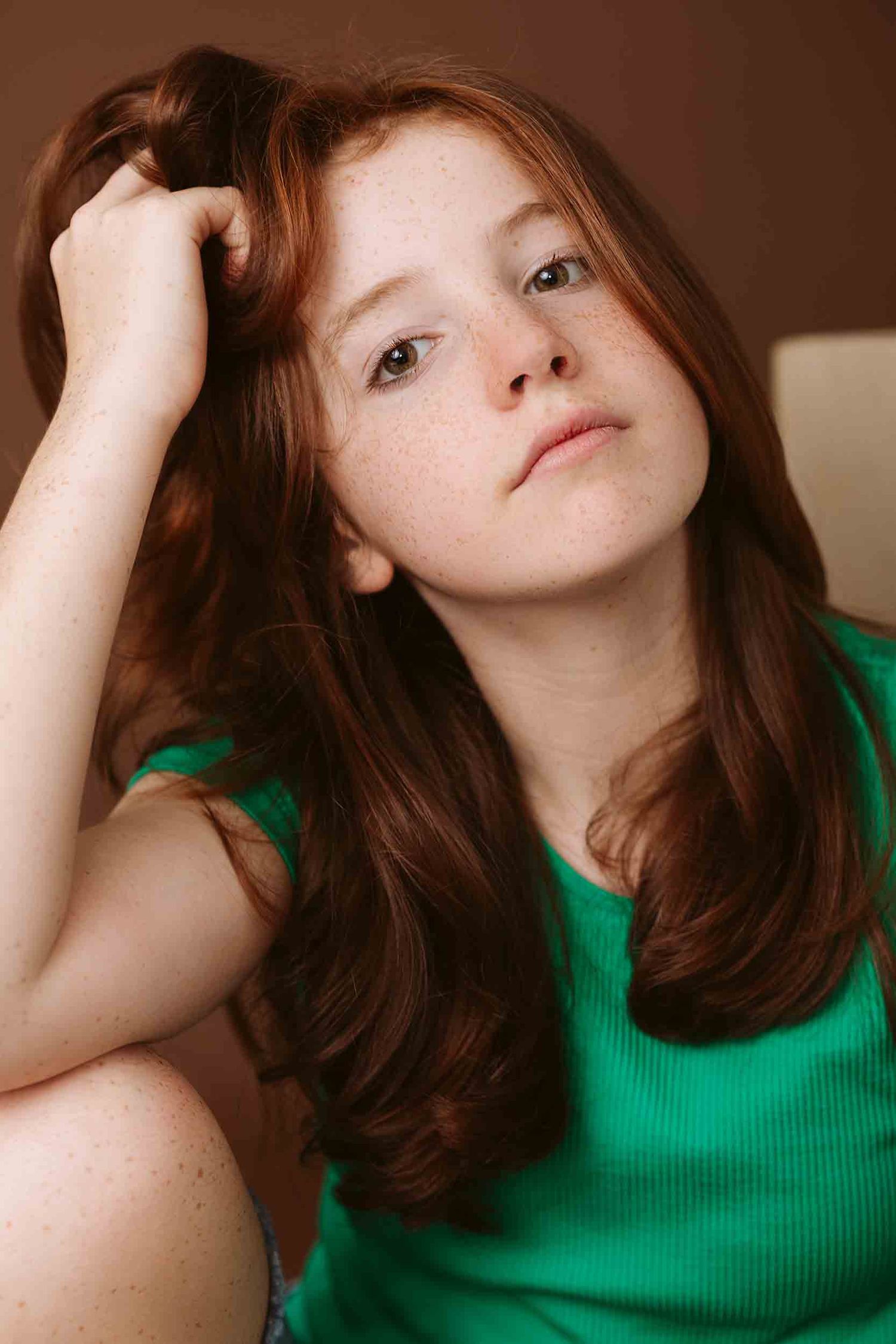 Artistic portrait series in green showing contemplative poses against warm brown background.