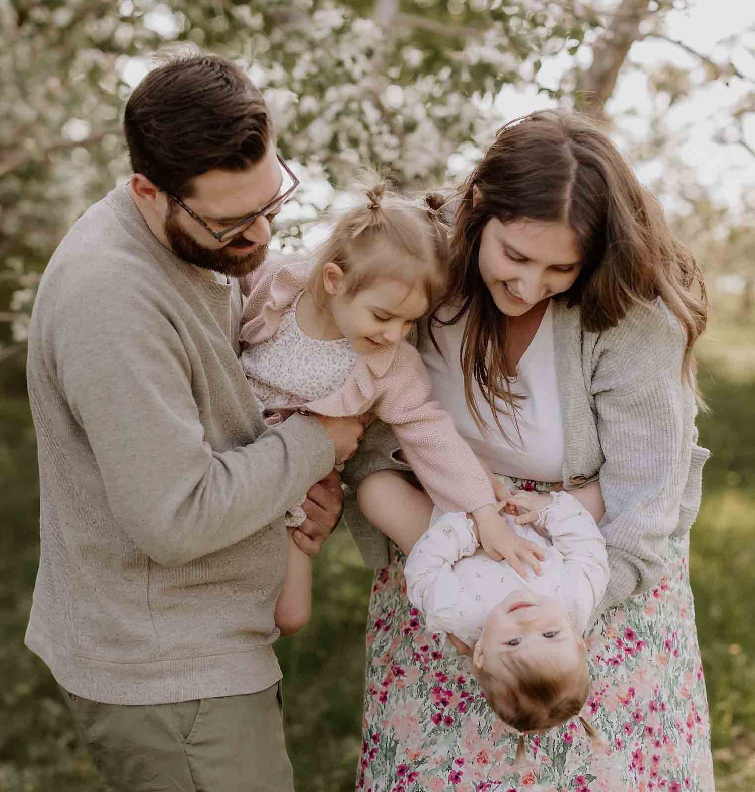 Family sharing tender moments together in a spring garden setting.