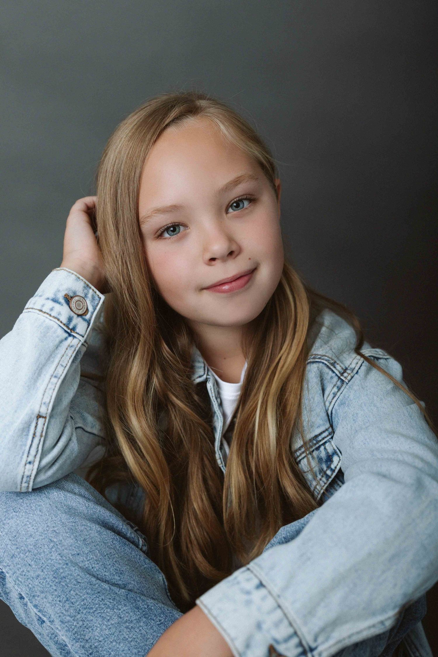 Series of casual poses in denim jacket against dark gray studio background.