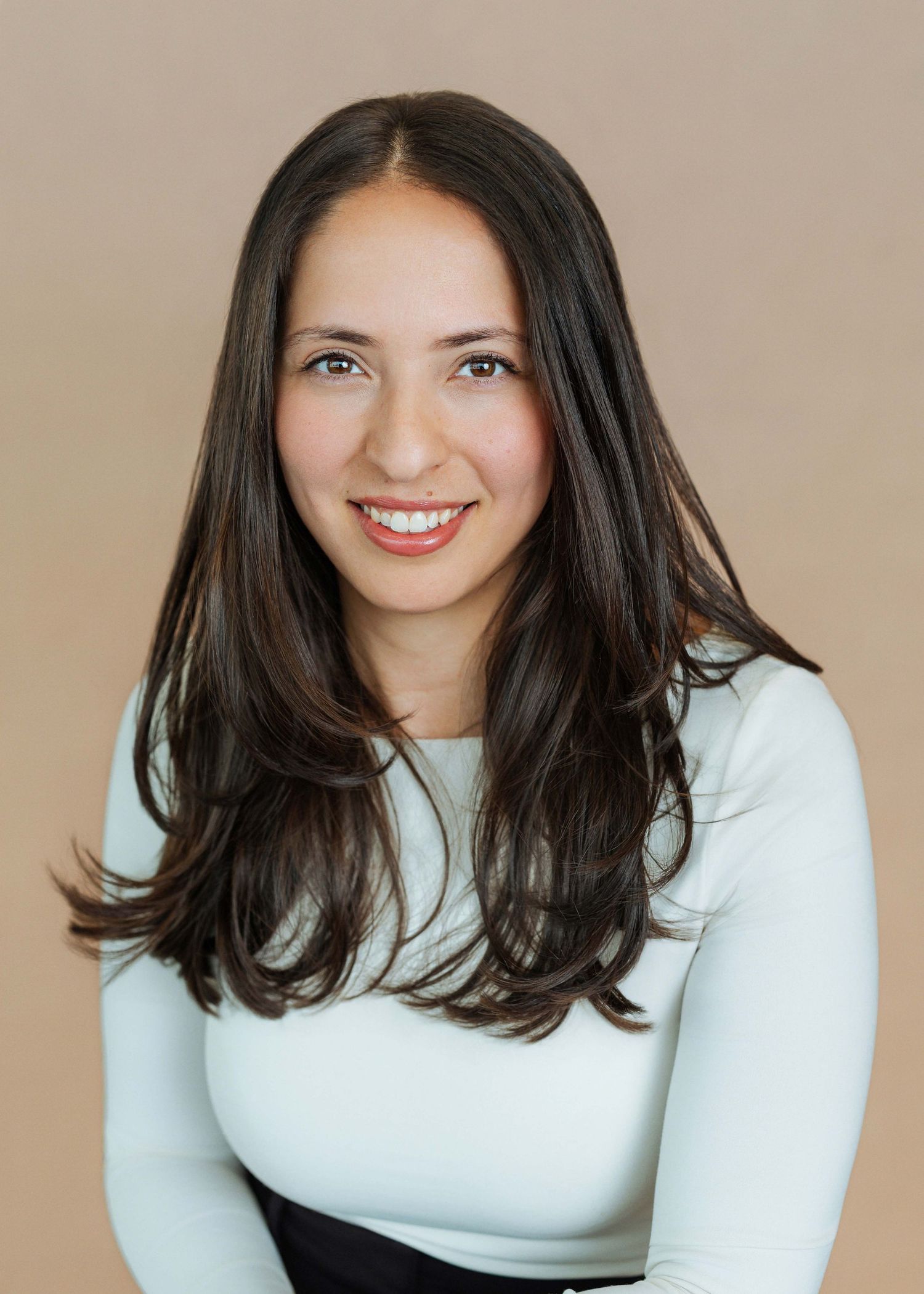 A series of five photos showing someone in a white long-sleeved top with dark hair against a beige background.