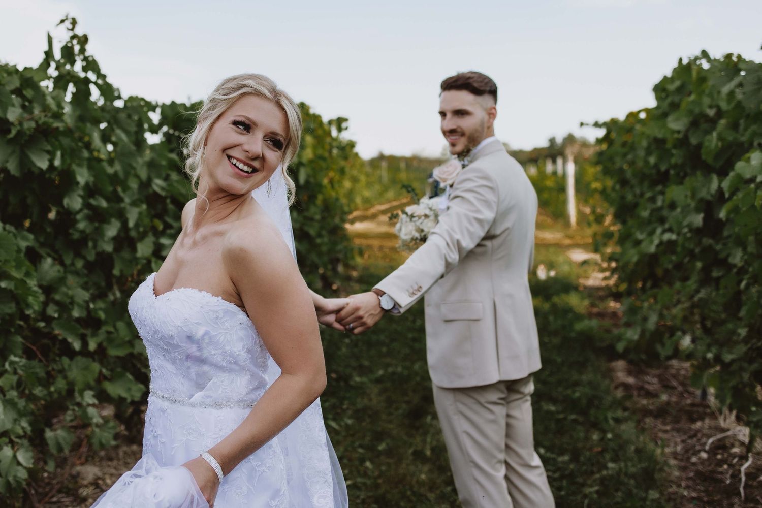 Candid wedding moments captured in vineyard setting during golden hour.