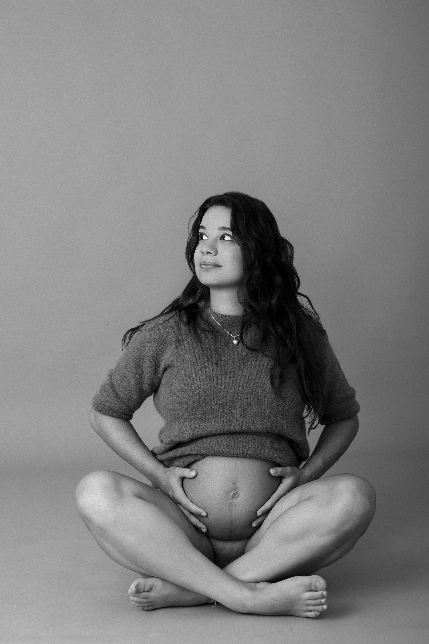 Serene maternity portrait in black and white showing pregnant belly.