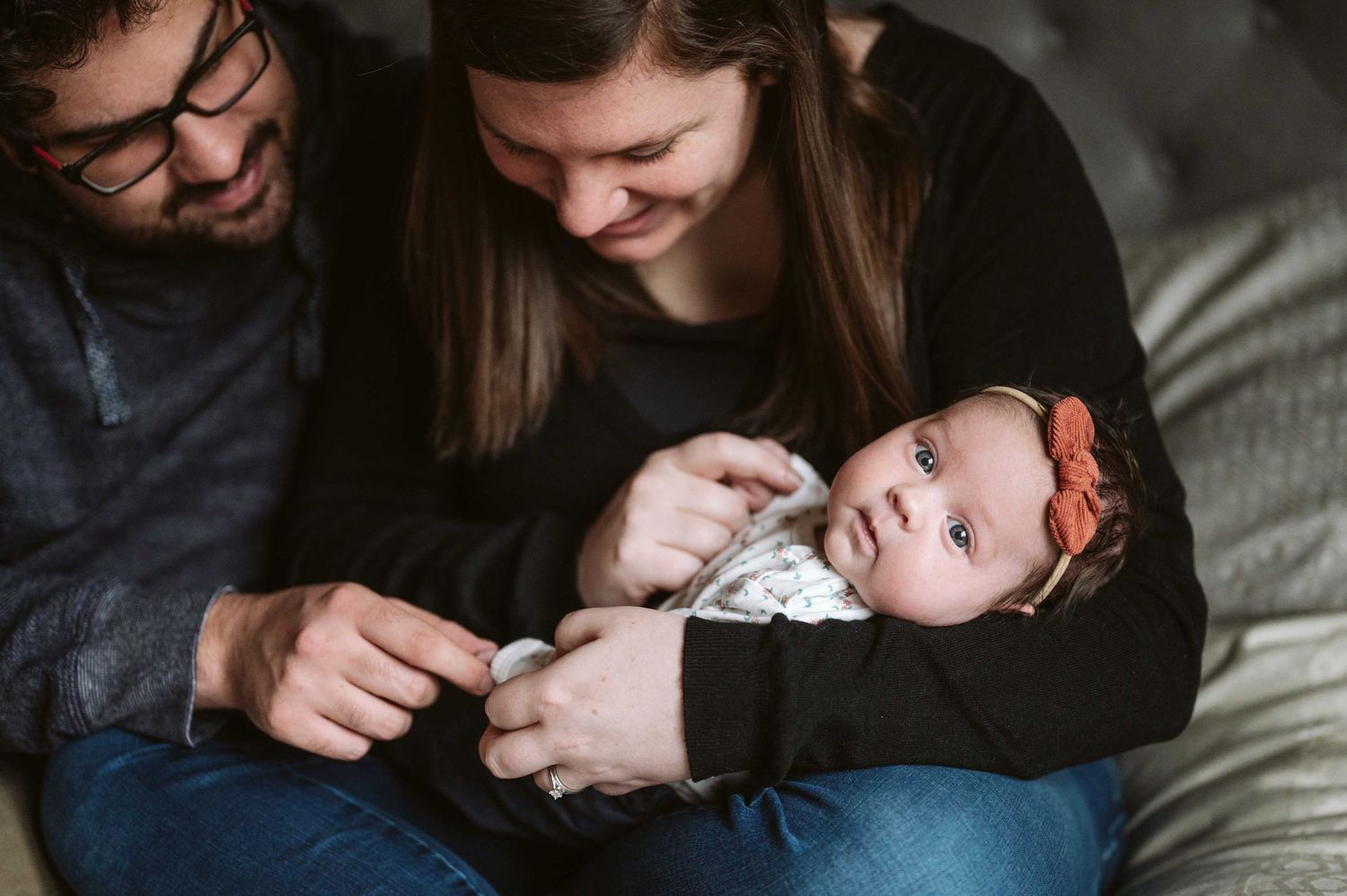Intimate lifestyle photography session showing tender moments on a gray couch.