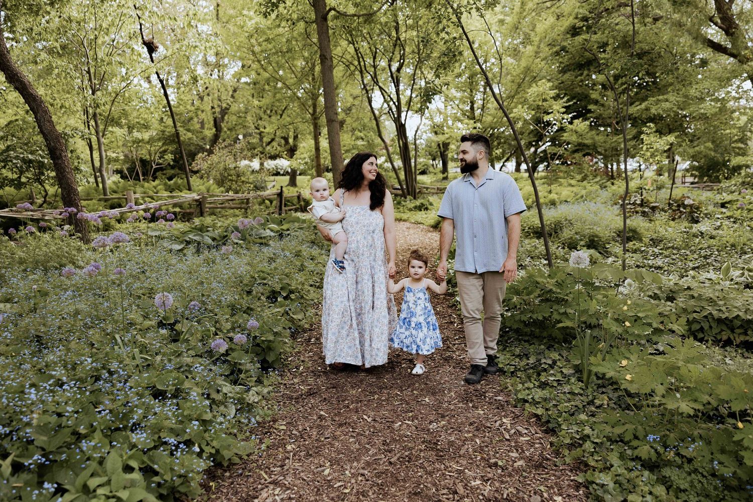 Group walking together on a winding forest path surrounded by lush greenery.