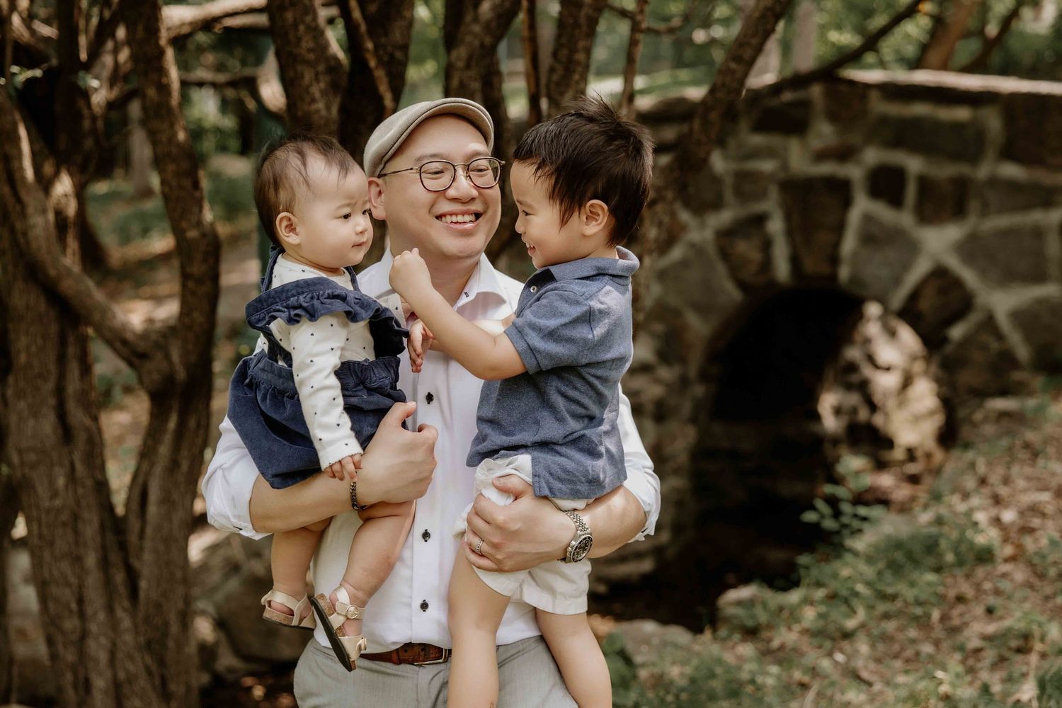 Family enjoying a playful moment together in a wooded outdoor setting.