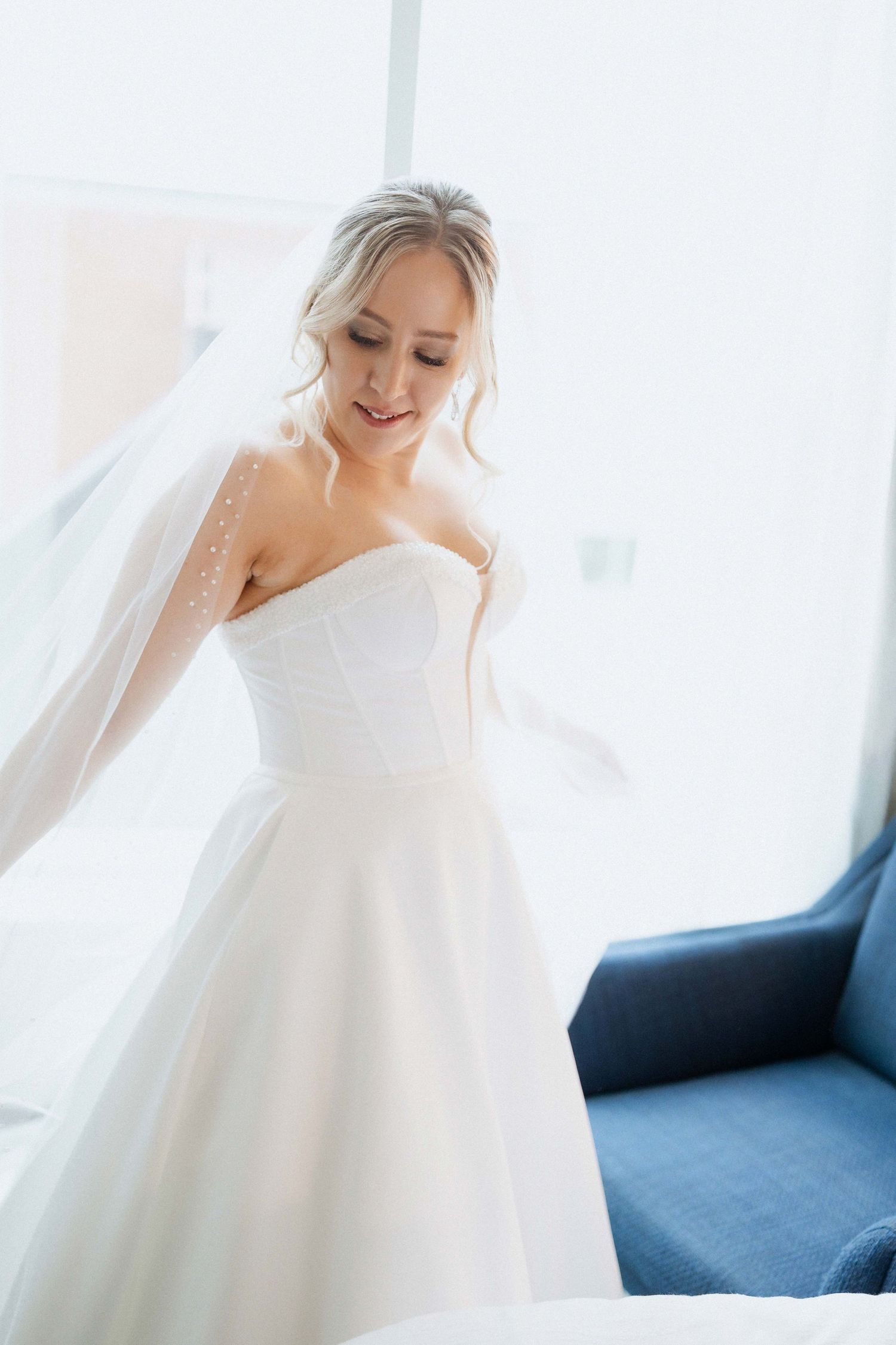 Ethereal bridal portrait with flowing white wedding dress in natural light.