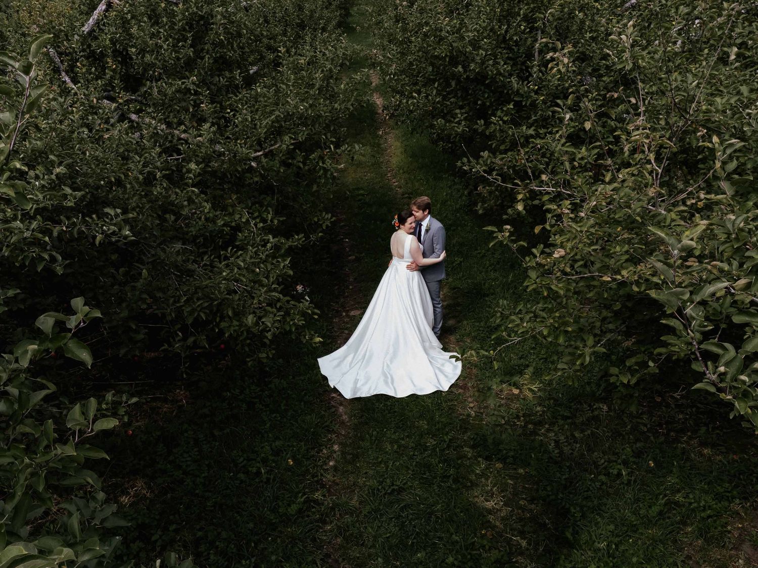 Wedding couple shares romantic moments in lush garden setting.