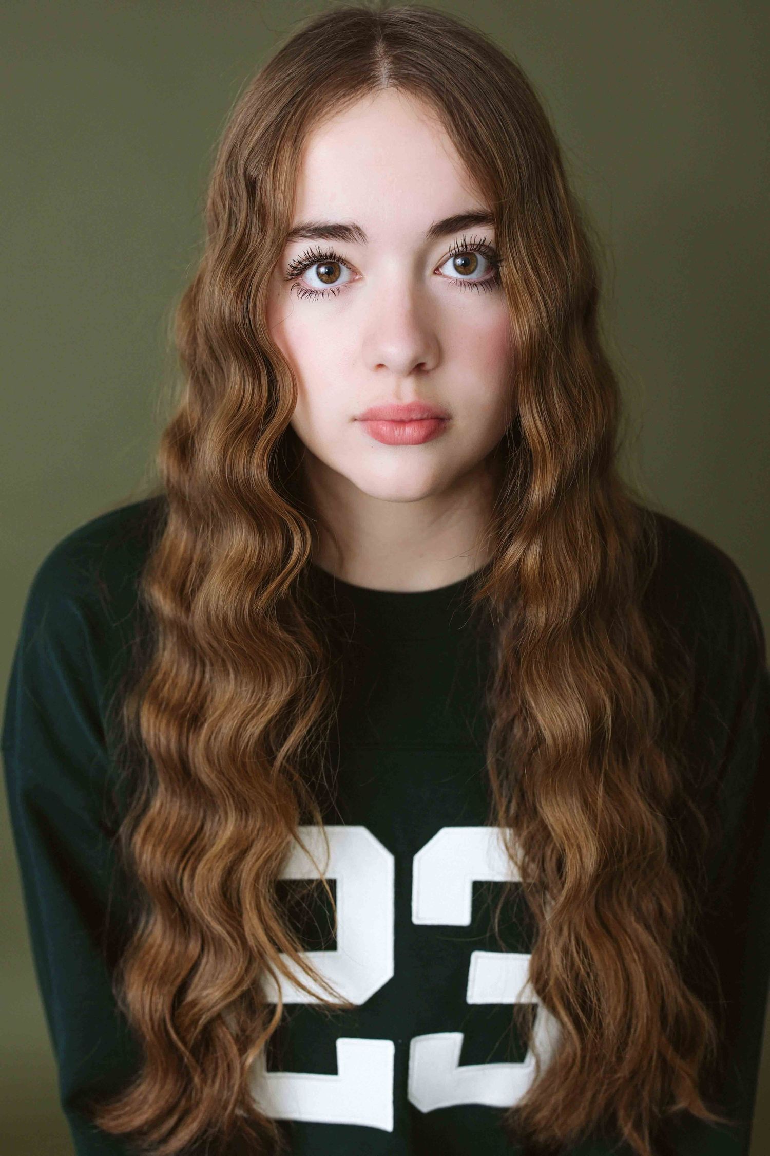 Portrait series showing long wavy brown hair and dark jersey against green background.