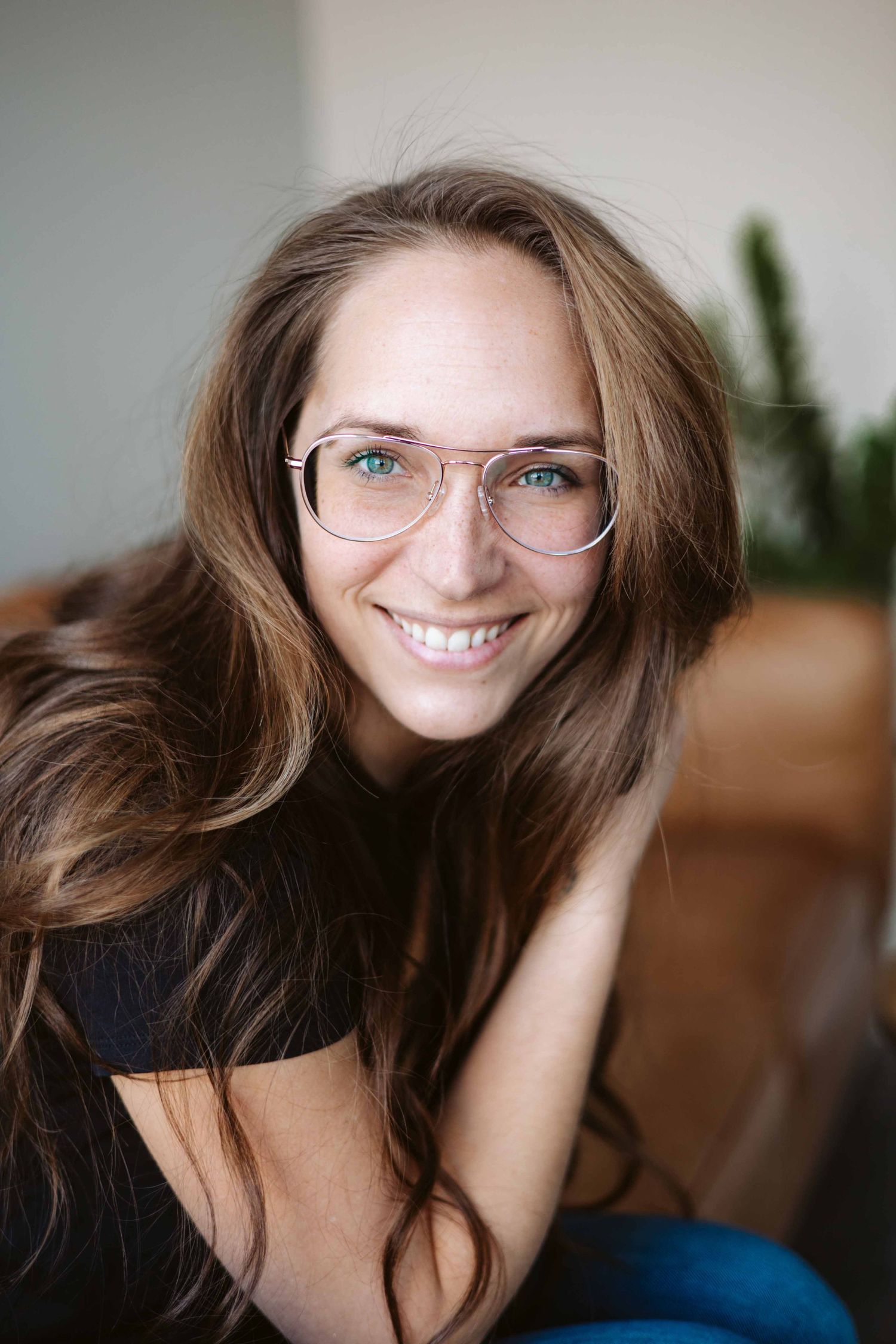 Natural lifestyle portrait of person with glasses in casual indoor setting.