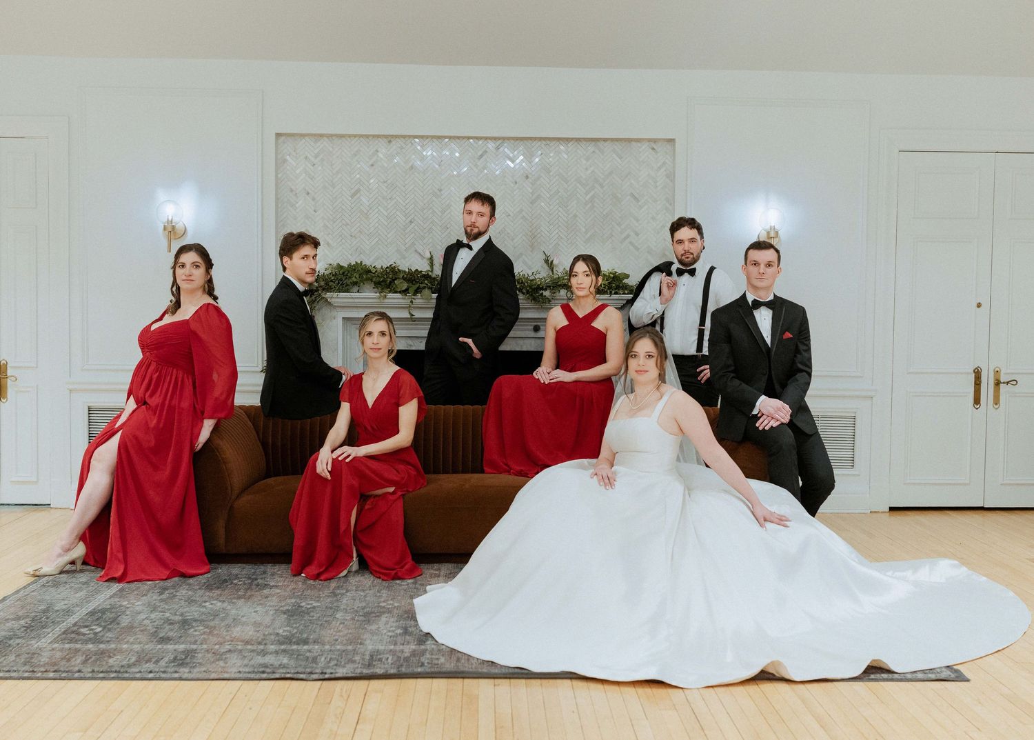 A wedding party poses in a sequence of photos showing bridesmaids in red dresses and a bride in a white gown.