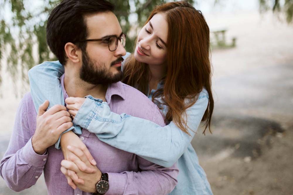 Romantic outdoor couple photoshoot with soft natural lighting and pastel colored clothing.