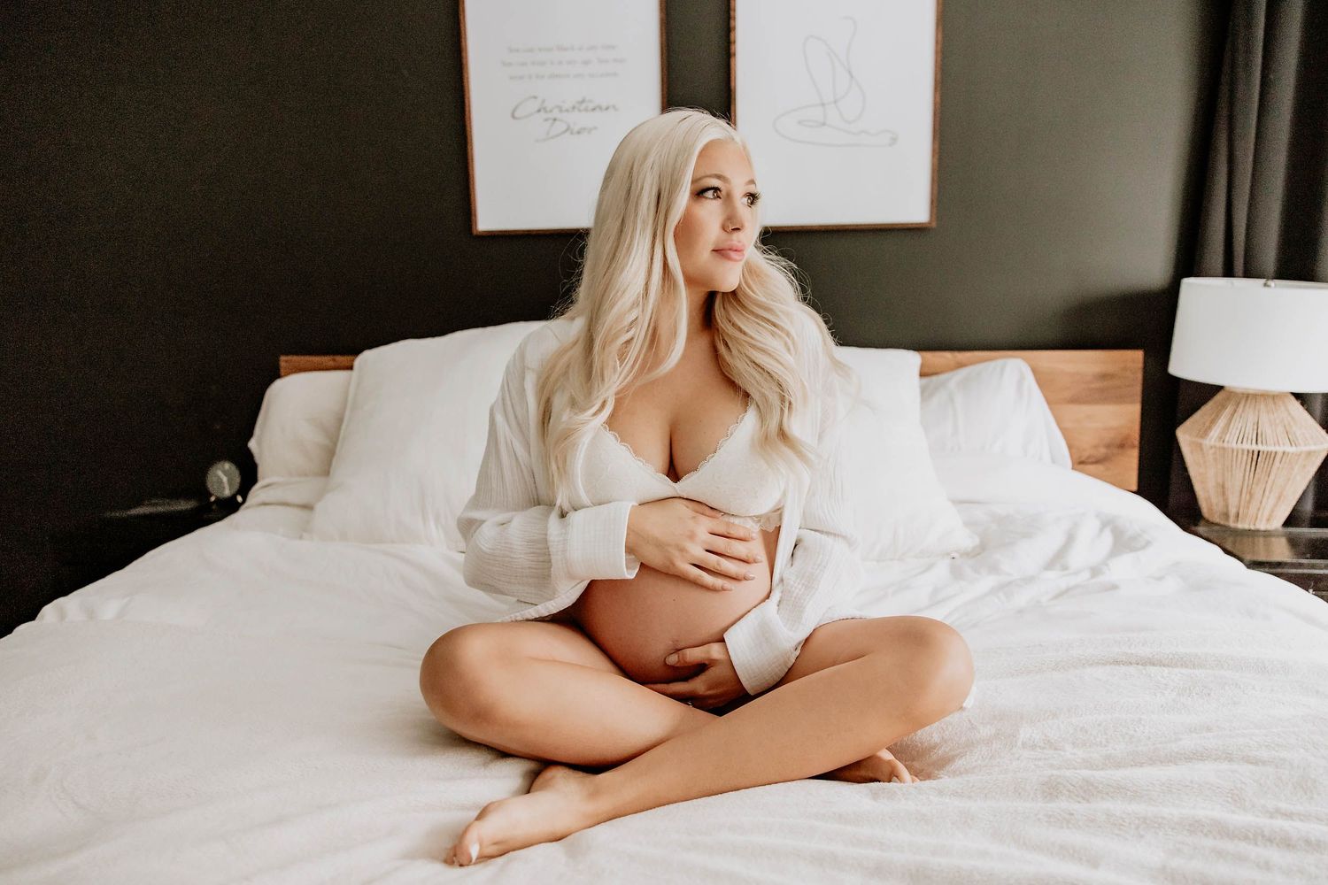 Intimate boudoir photography session in a bright bedroom with white bedding.