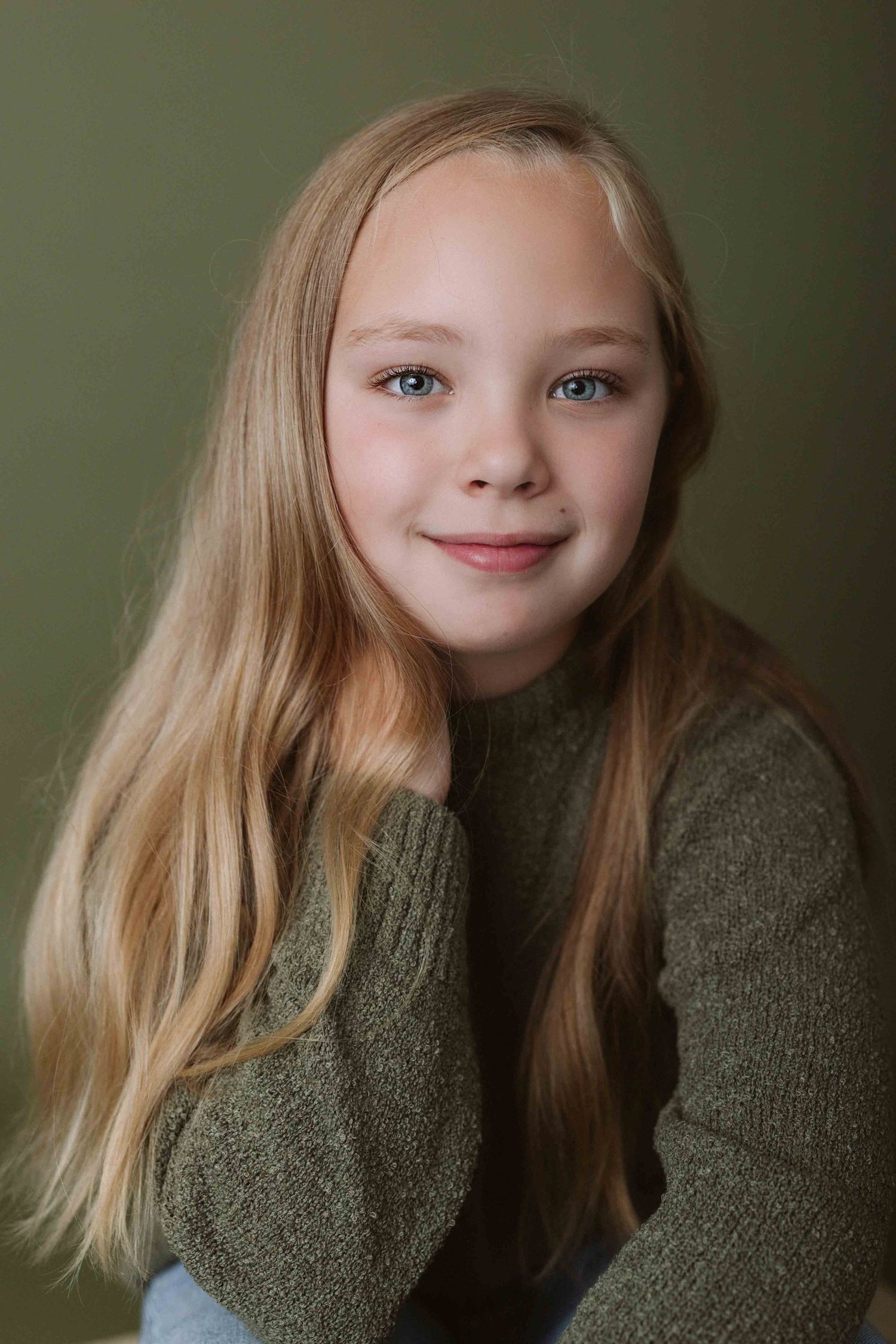 Portrait series showing contemplative poses in olive green sweater against muted background.