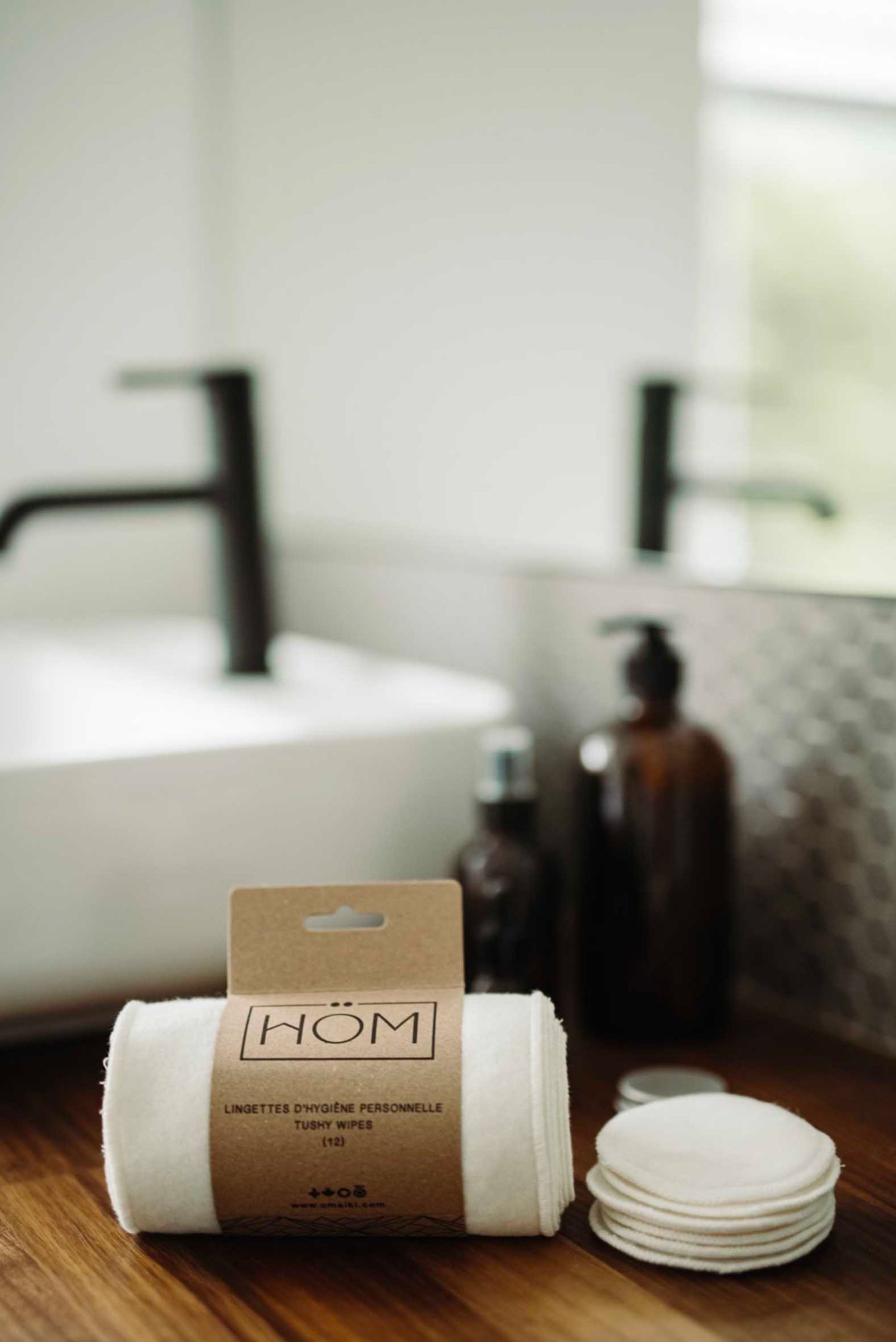 Eco-friendly reusable cotton rounds displayed with minimal packaging on a wooden surface.