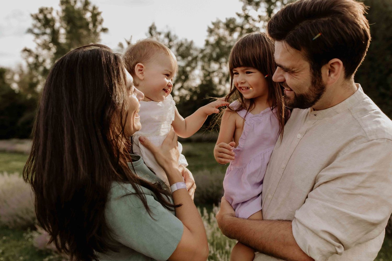 Intimate family moments captured outdoors with natural sunset lighting.