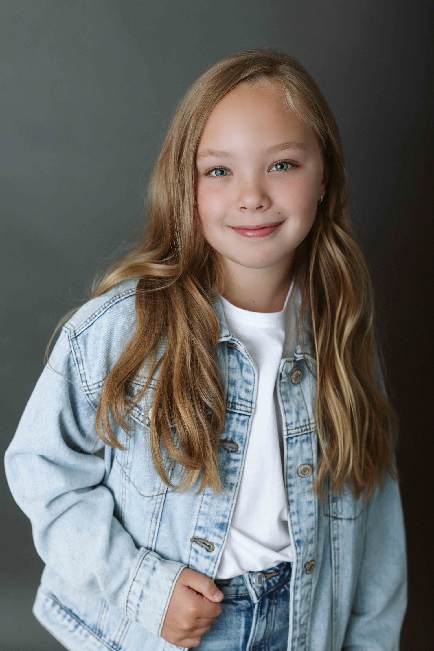 Portrait series showing playful expressions while wearing light denim jacket and white top.