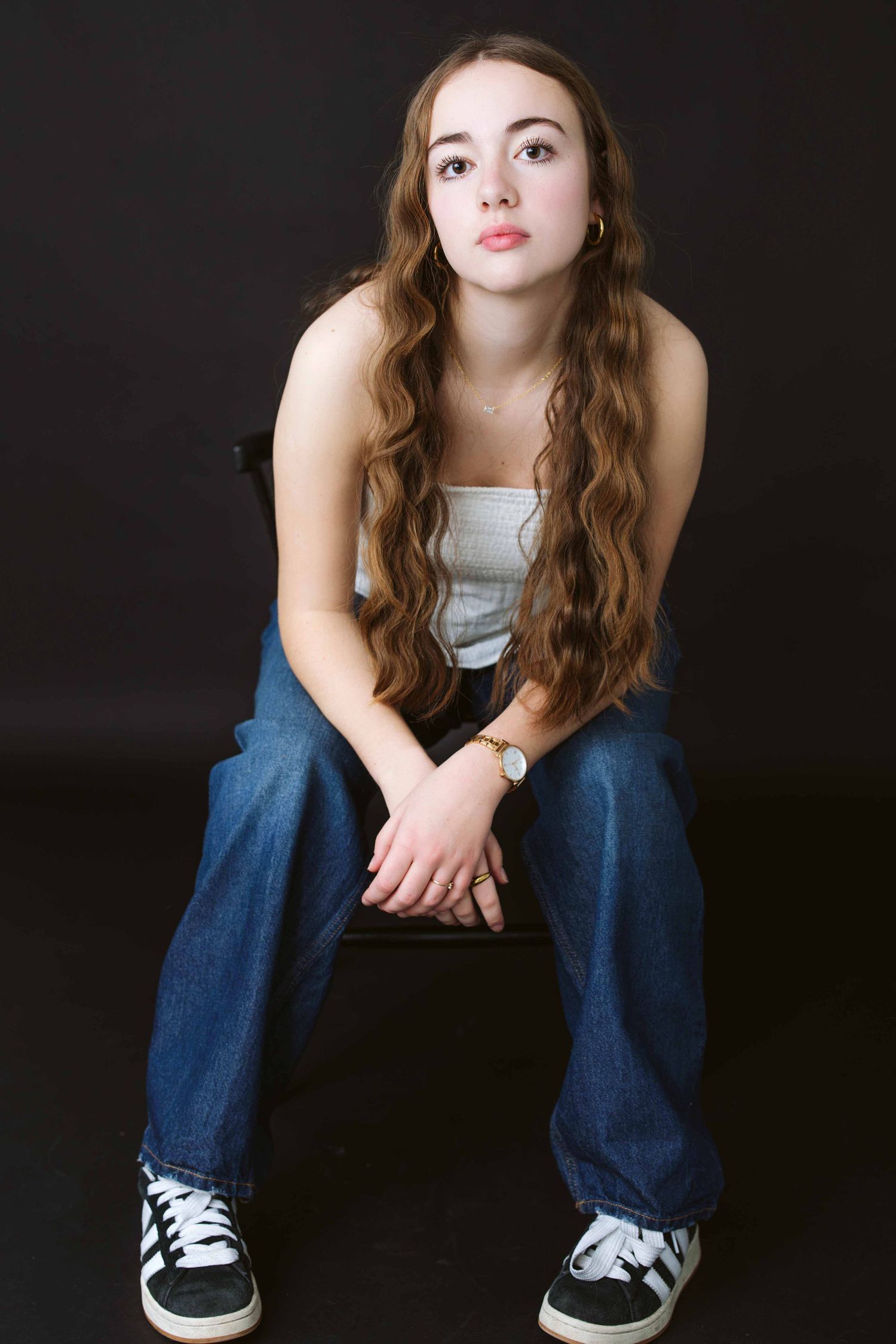 Casual portrait series showing denim and white top against dark background.