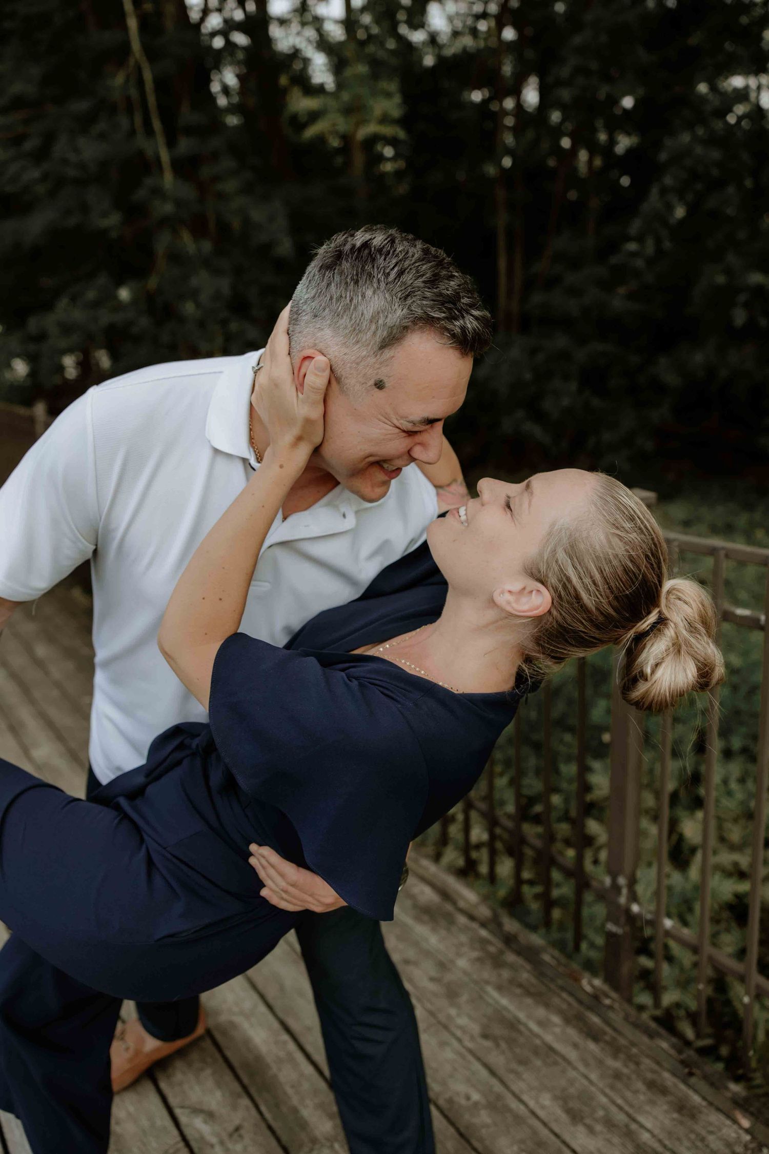 A couple dances and dips on a wooden deck in dramatic lighting.