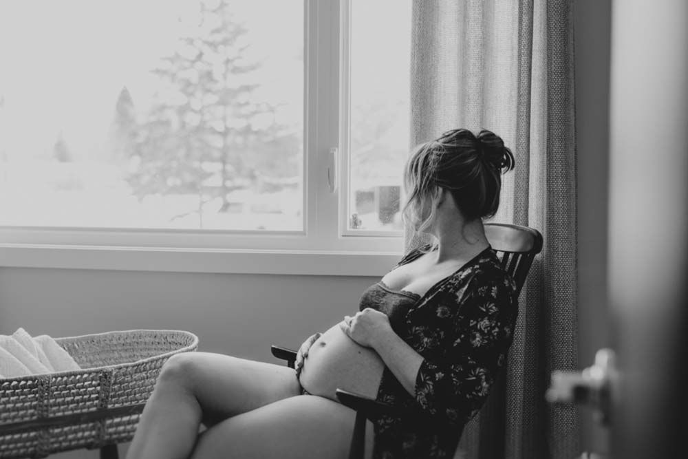 A romantic black and white photo of a couple sharing an intimate moment in an indoor setting.