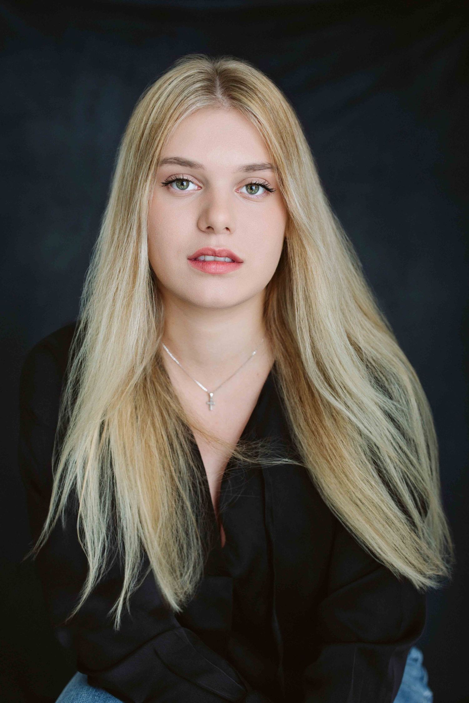 Dramatic portraits featuring blonde hair and black clothing against dark studio backdrop.