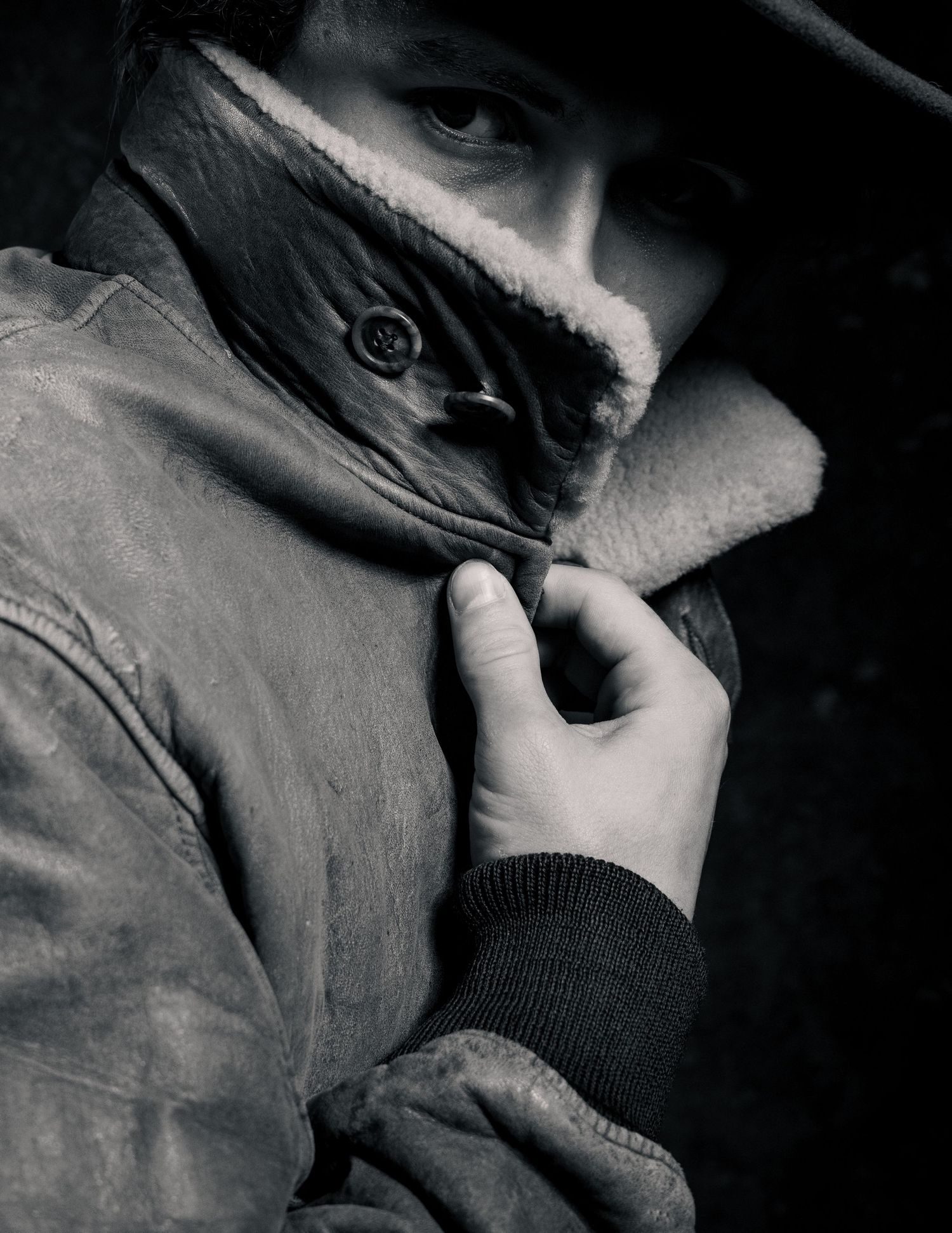 Dramatic black and white portrait series showing close-up details of a person wearing dark clothing.